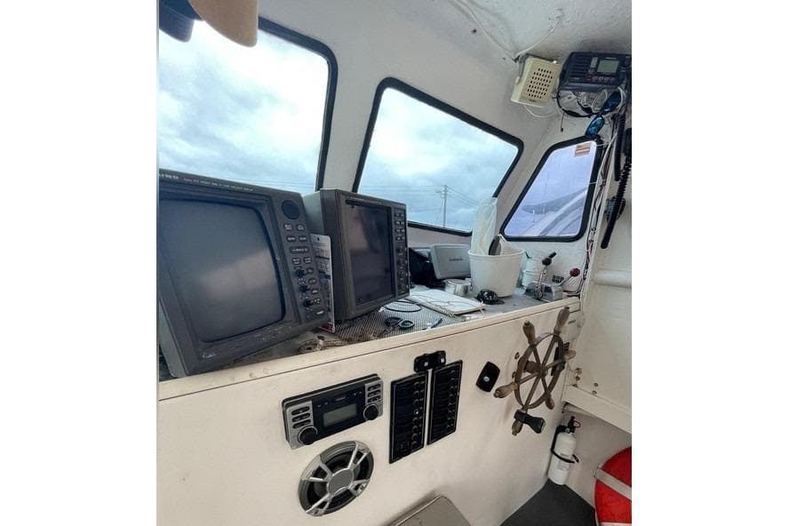 1977 JC 31 Casco Bay boat cockpit with navigation equipment and steering wheel.