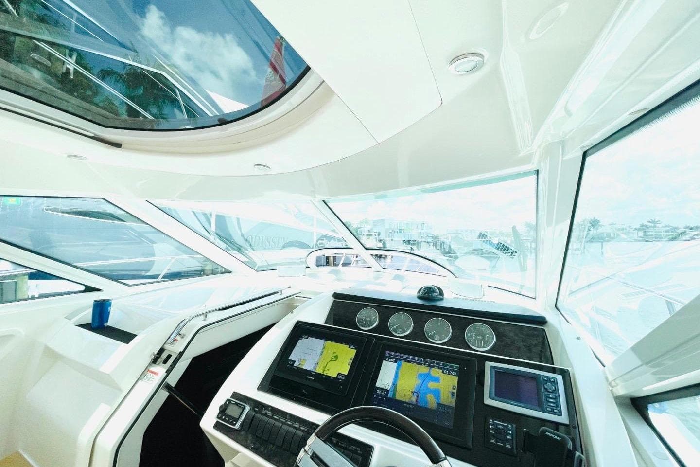 Helm of 2010 Sea Ray 450 Sundancer with navigation screens and panoramic windows.