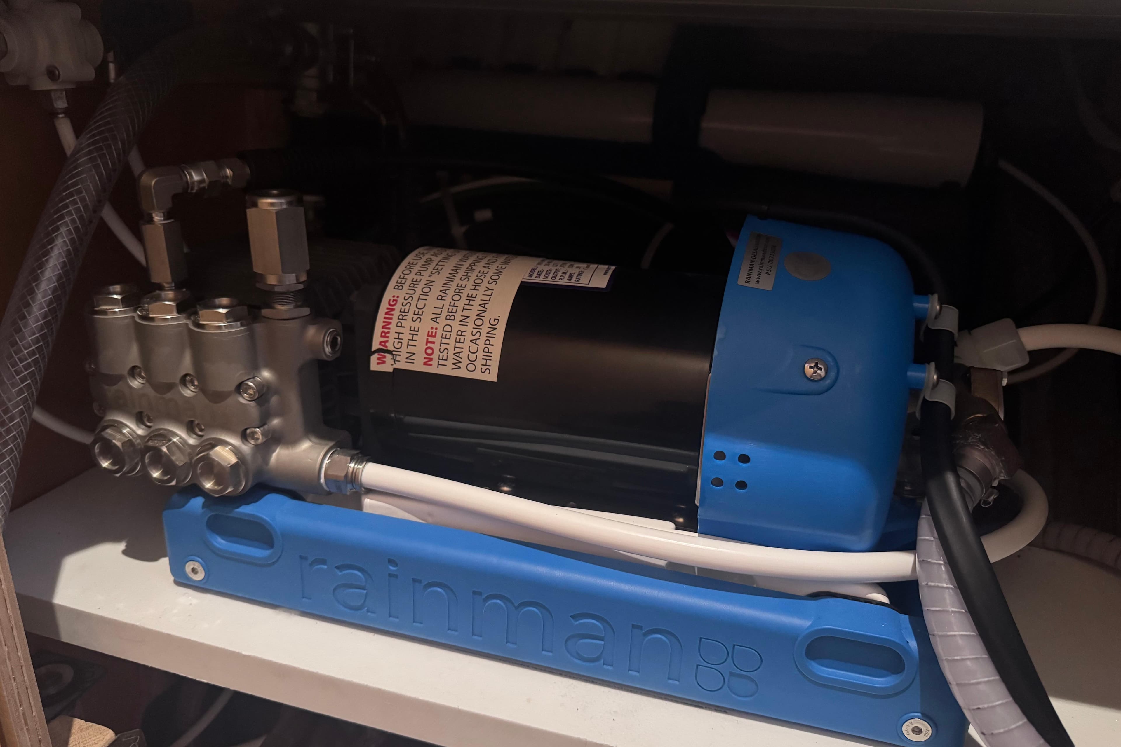 Rainman watermaker installed in a 2018 Lagoon 42 yacht, featuring blue casing and connected hoses.