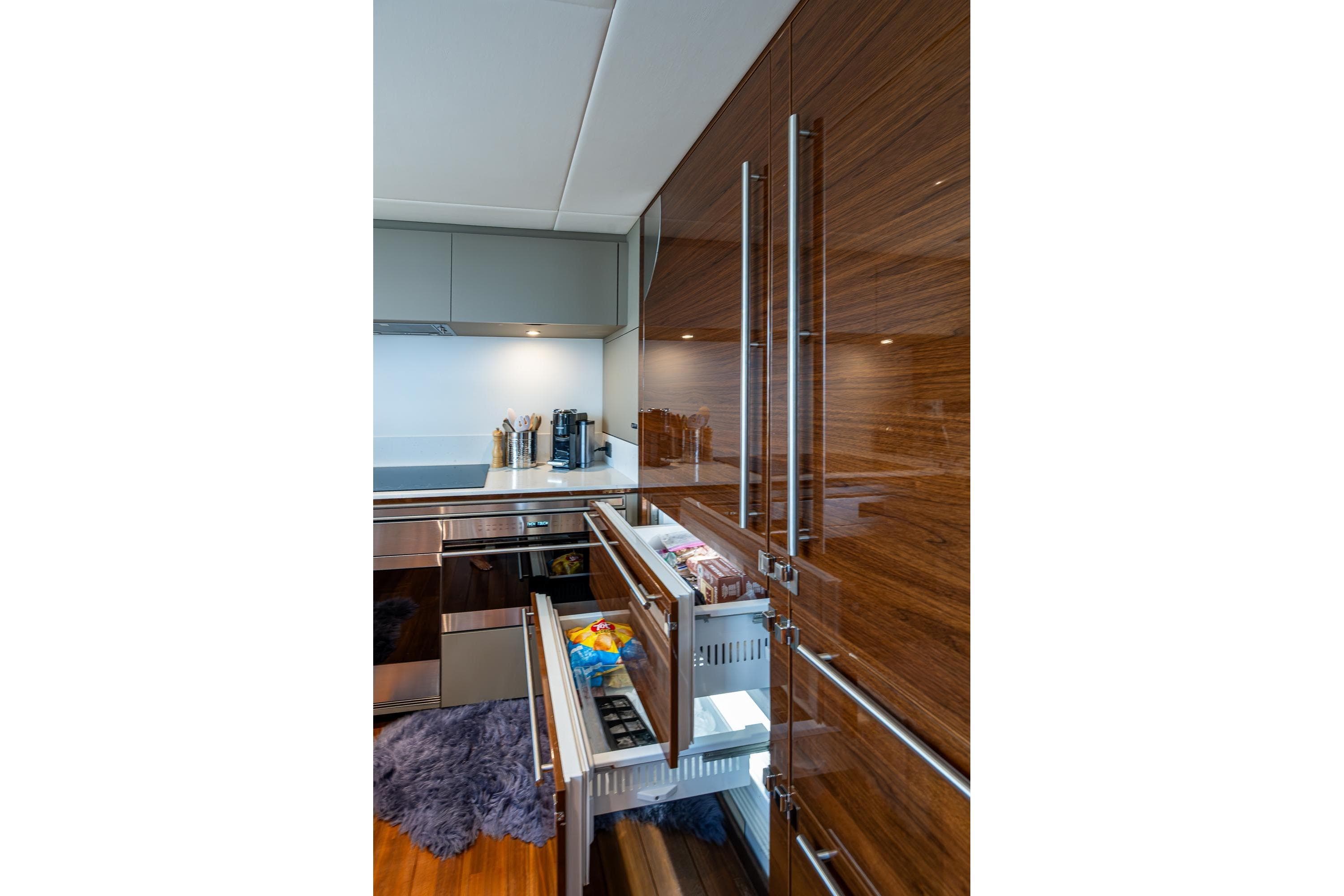 Luxurious kitchen interior of 2022 Princess X95 yacht with sleek cabinetry and modern appliances.