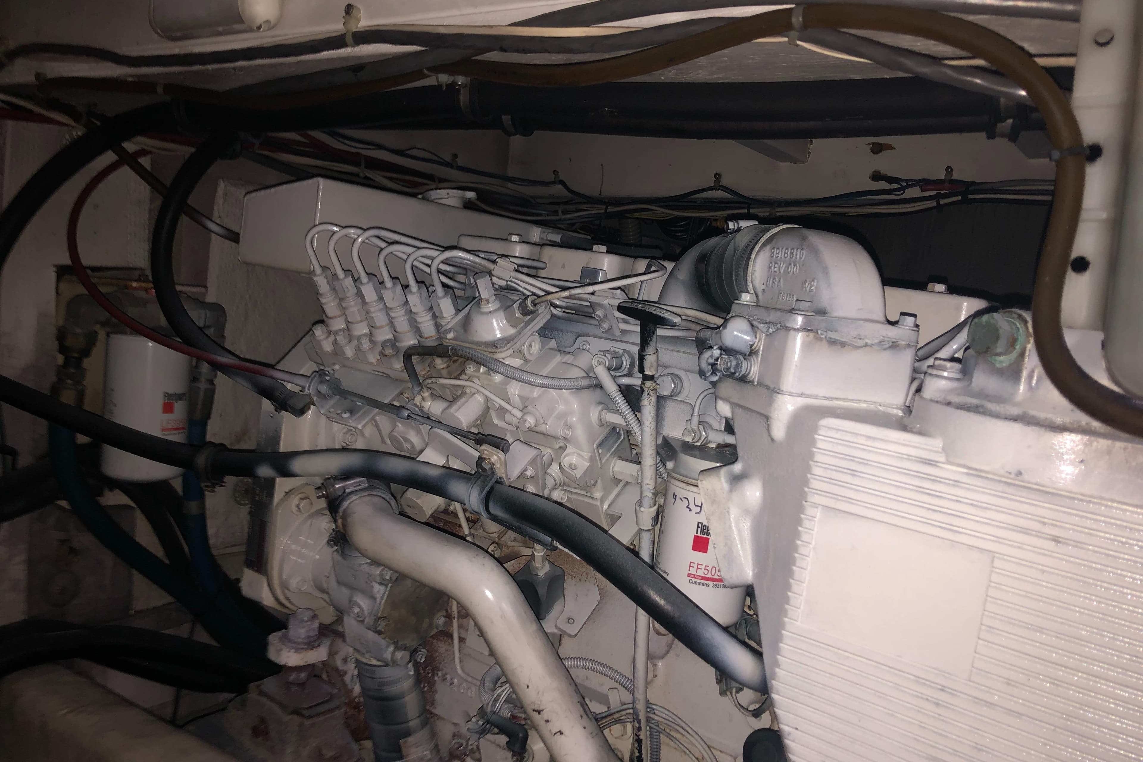 Engine compartment of a 1997 Bayliner 3988 Motor Yacht, showcasing mechanical components and wiring.