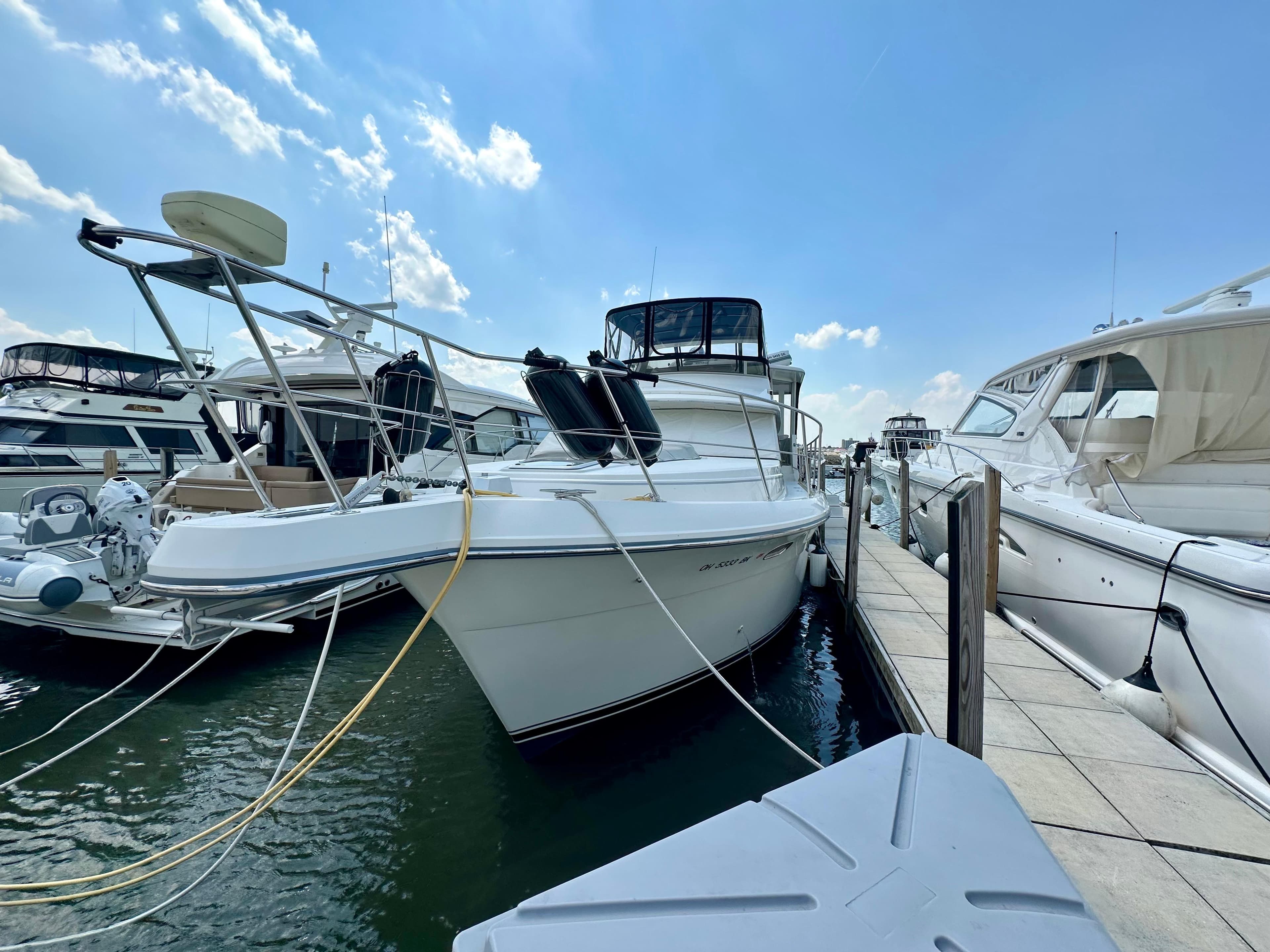 1995 Carver 440 Aft Cabin Motor Yacht docked at marina under blue sky.