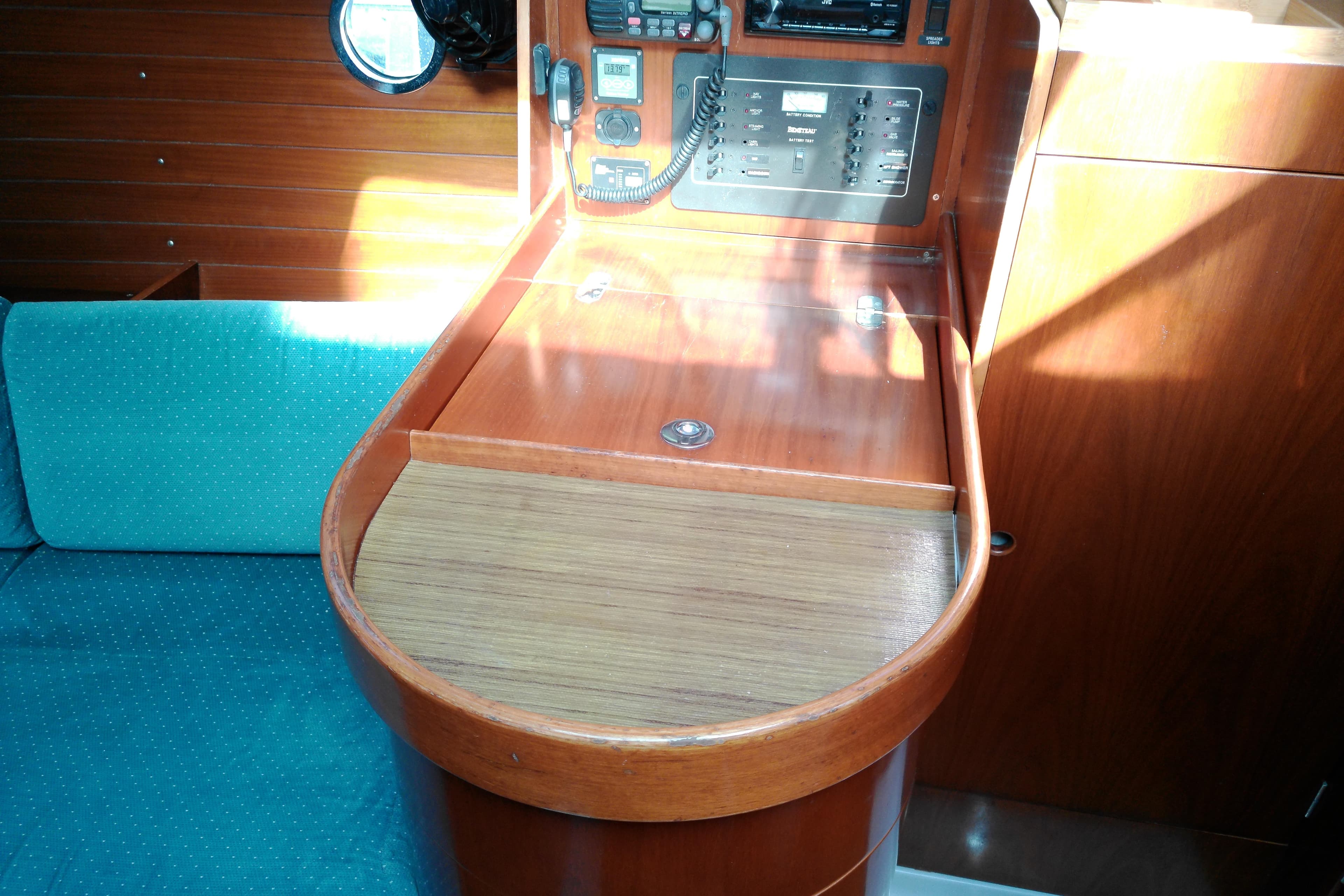 Interior of 1993 Beneteau First 310 sailboat with navigation station and teal seating.