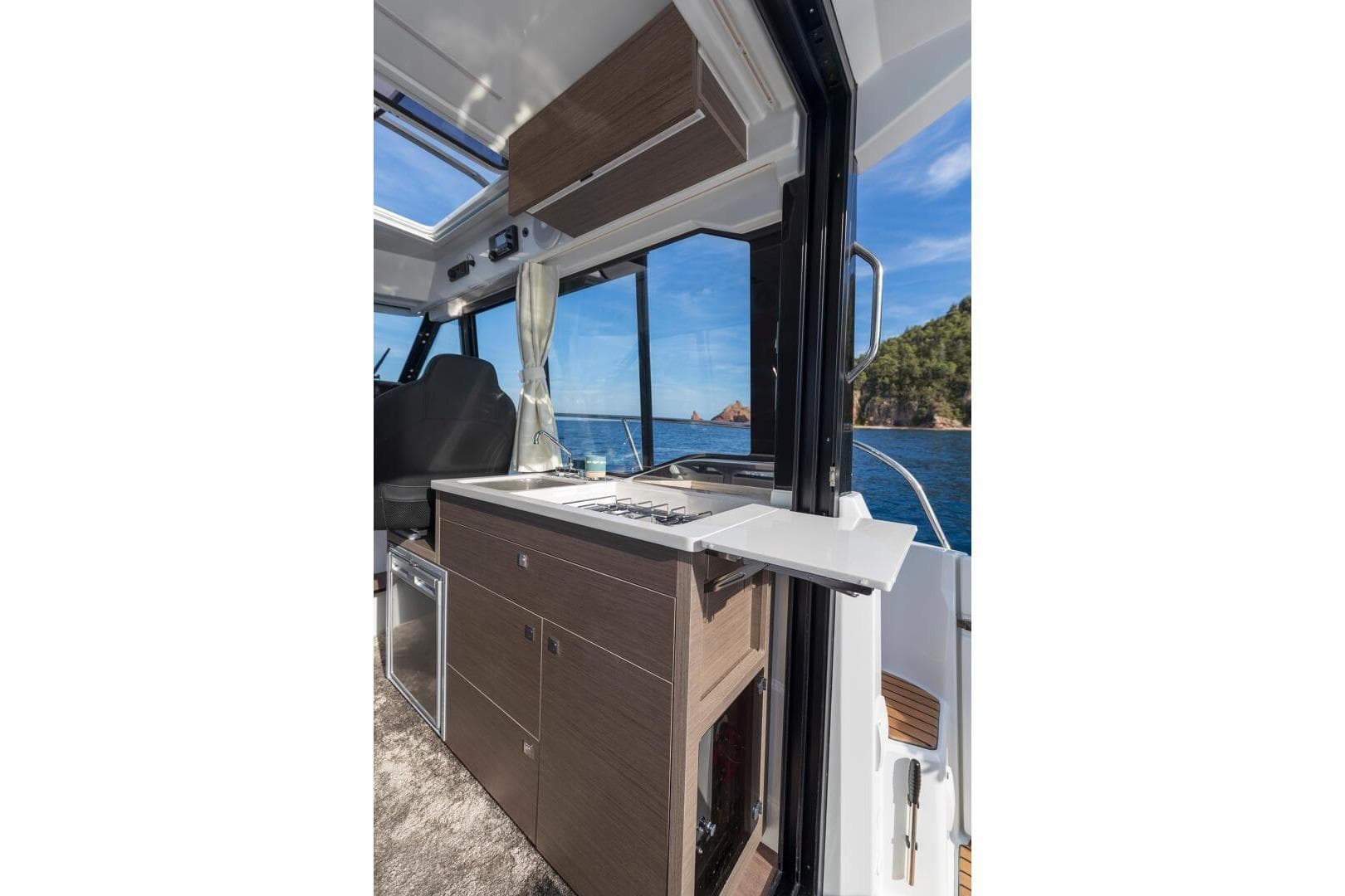 2025 Jeanneau NC895 S2 interior with kitchenette, ocean view, and modern design.
