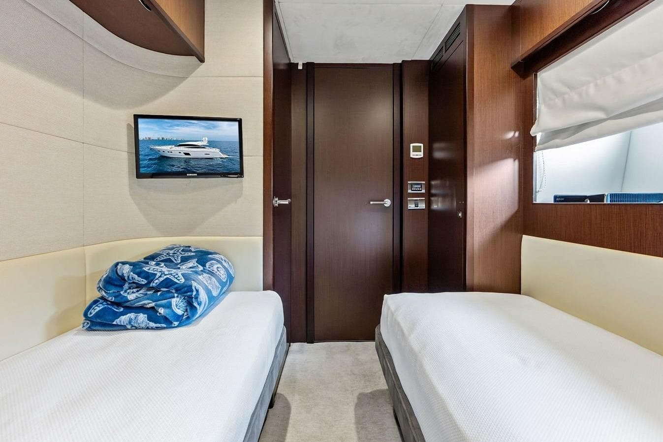 Luxurious cabin interior of 2013 Princess 78 yacht with twin beds and TV.
