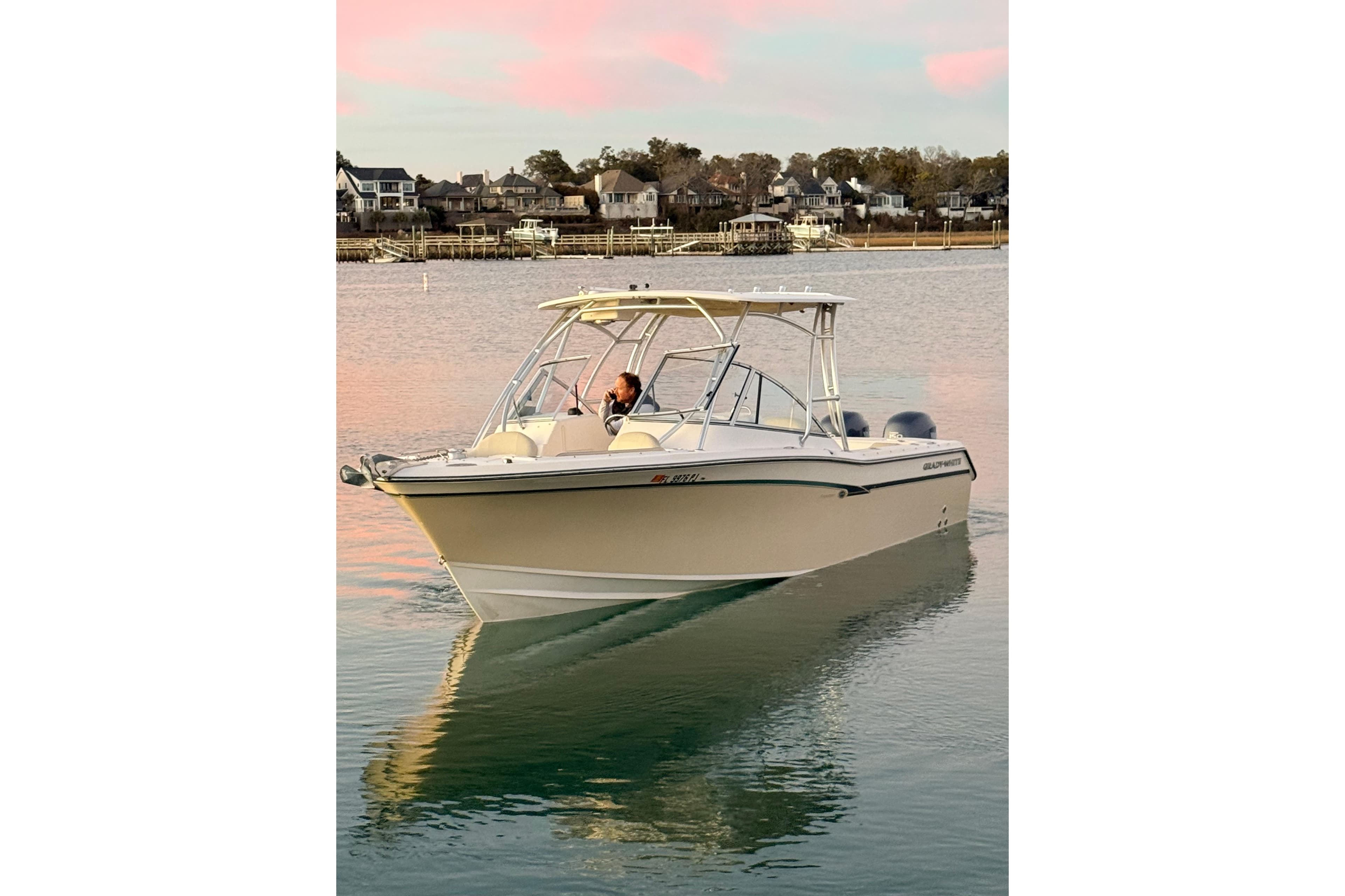 2012 Grady-White Freedom 275 boat cruising on calm water at sunset.