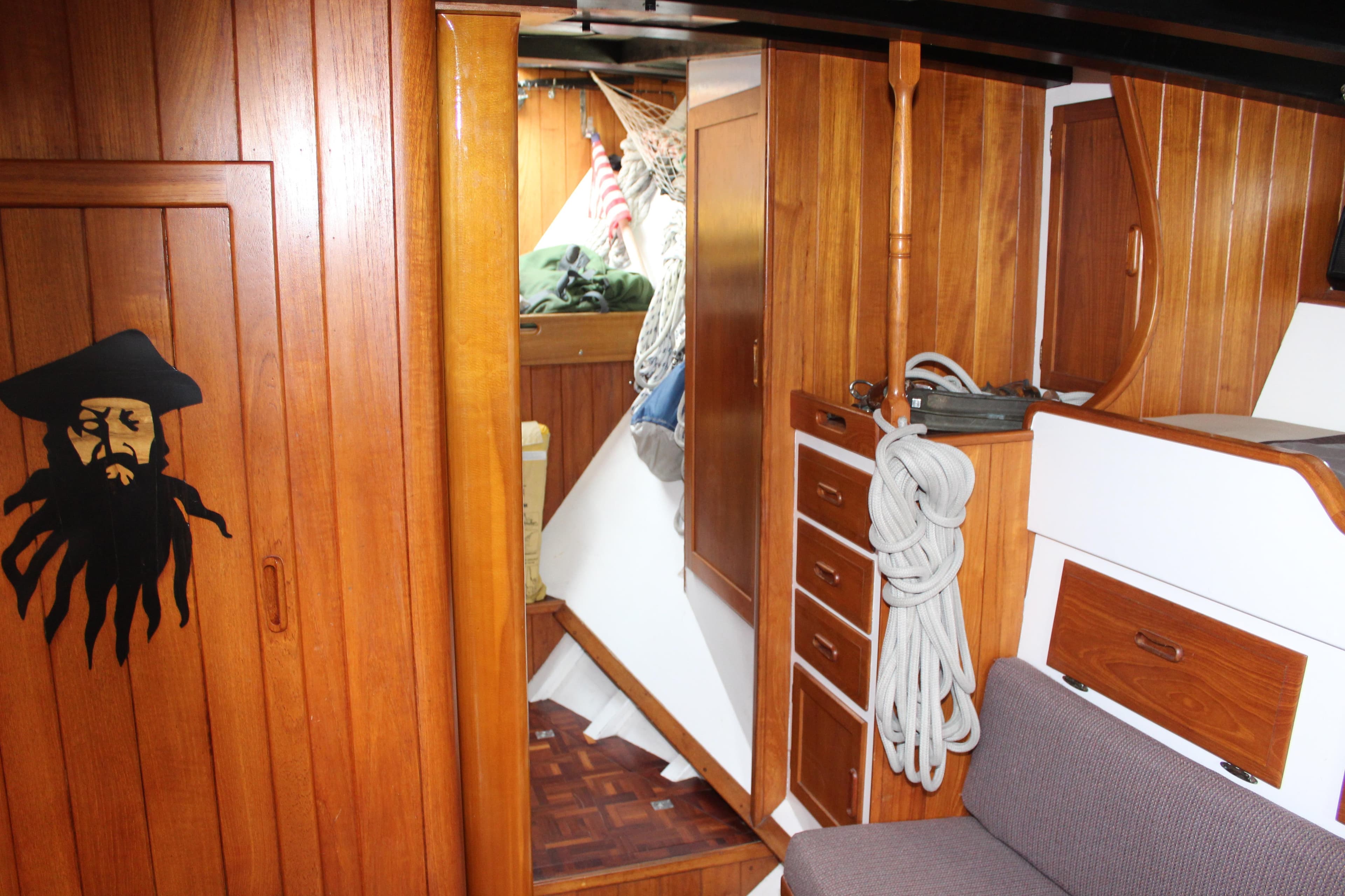 Interior of 1975 William Garden Porpoise sailboat with wooden cabinetry and pirate-themed decor.