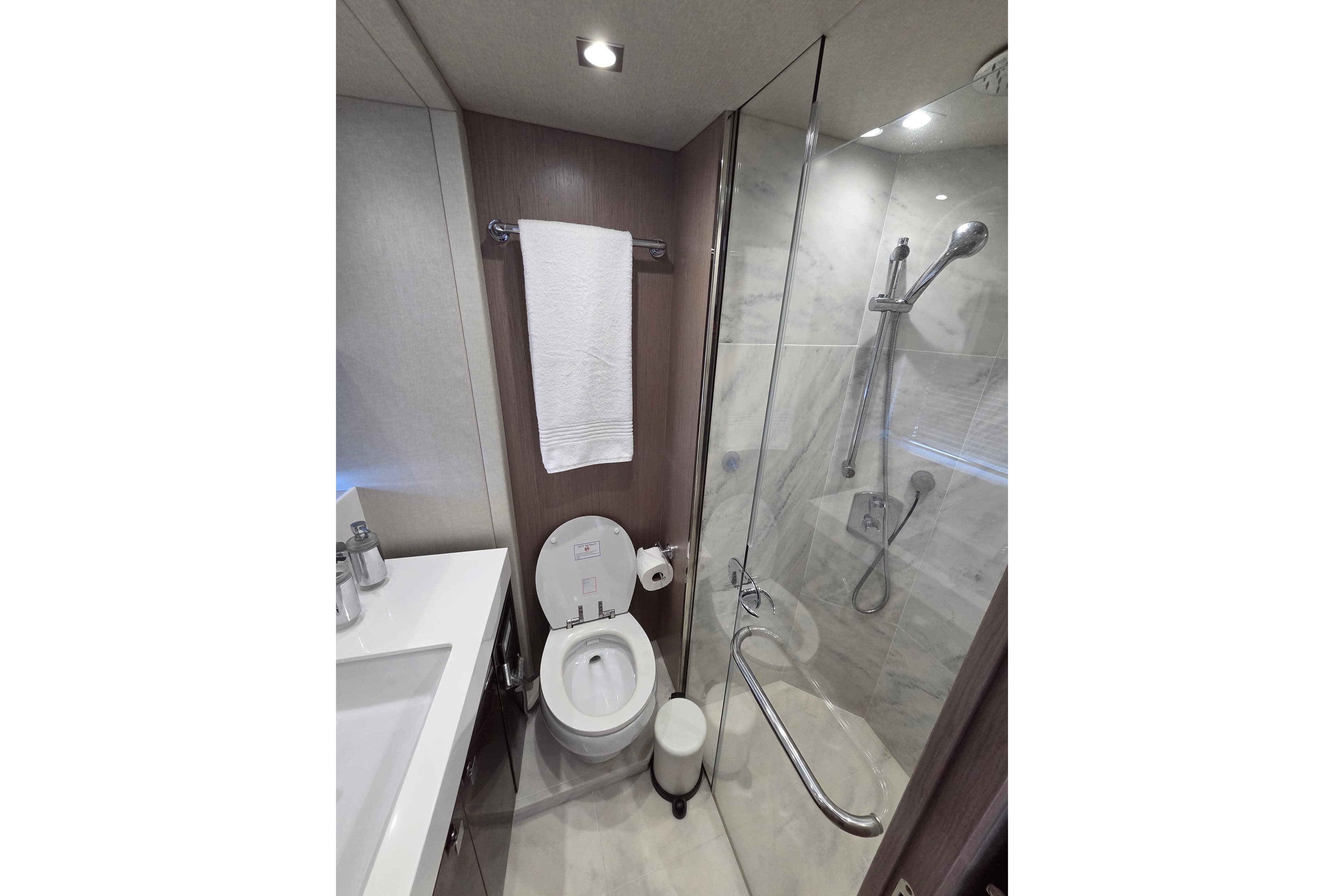 Luxurious bathroom in 2018 Sunseeker 76 Yacht with modern fixtures and glass shower.