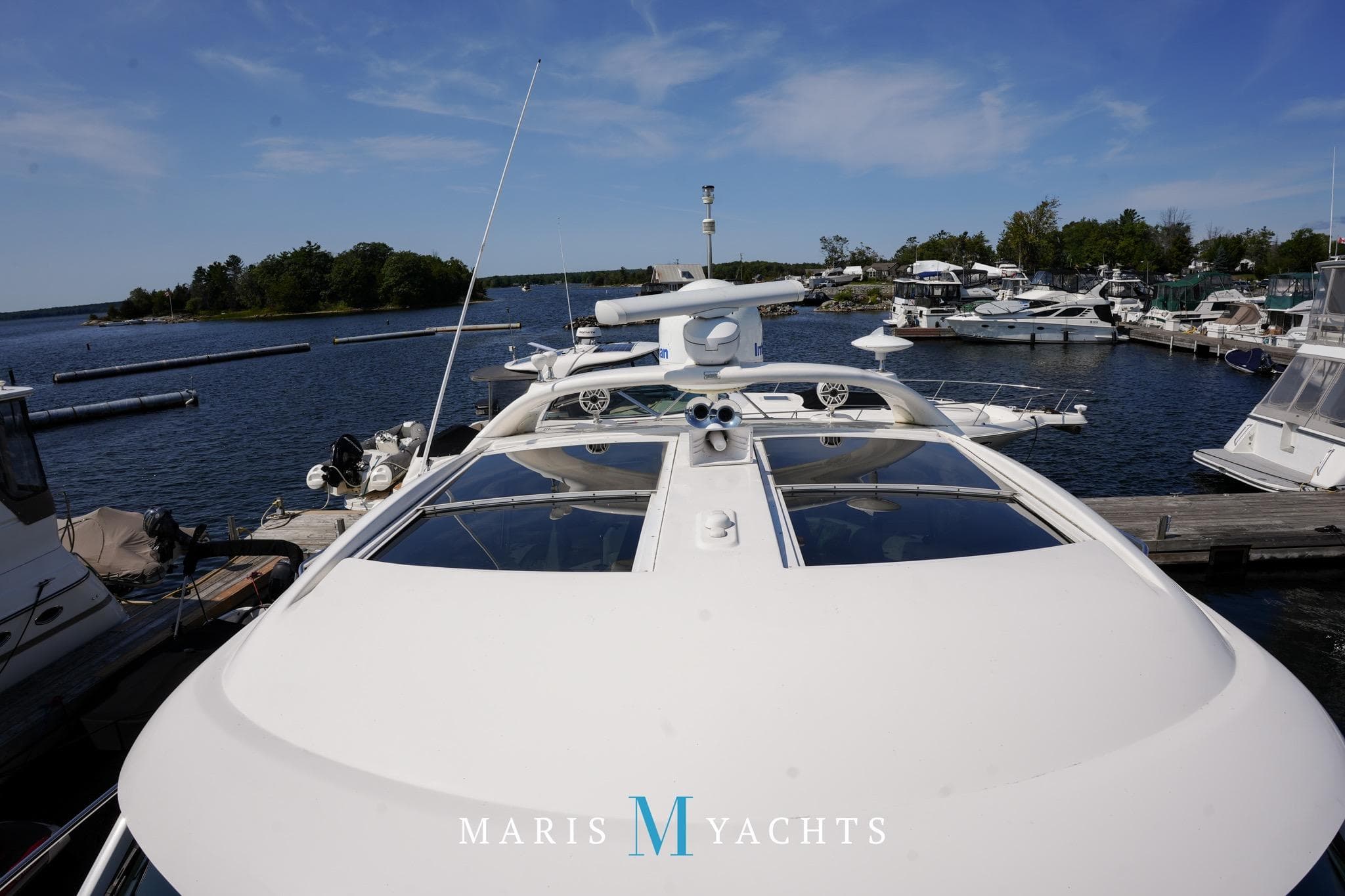 2009 Sea Ray 55 Sundancer yacht docked at marina under clear blue sky.