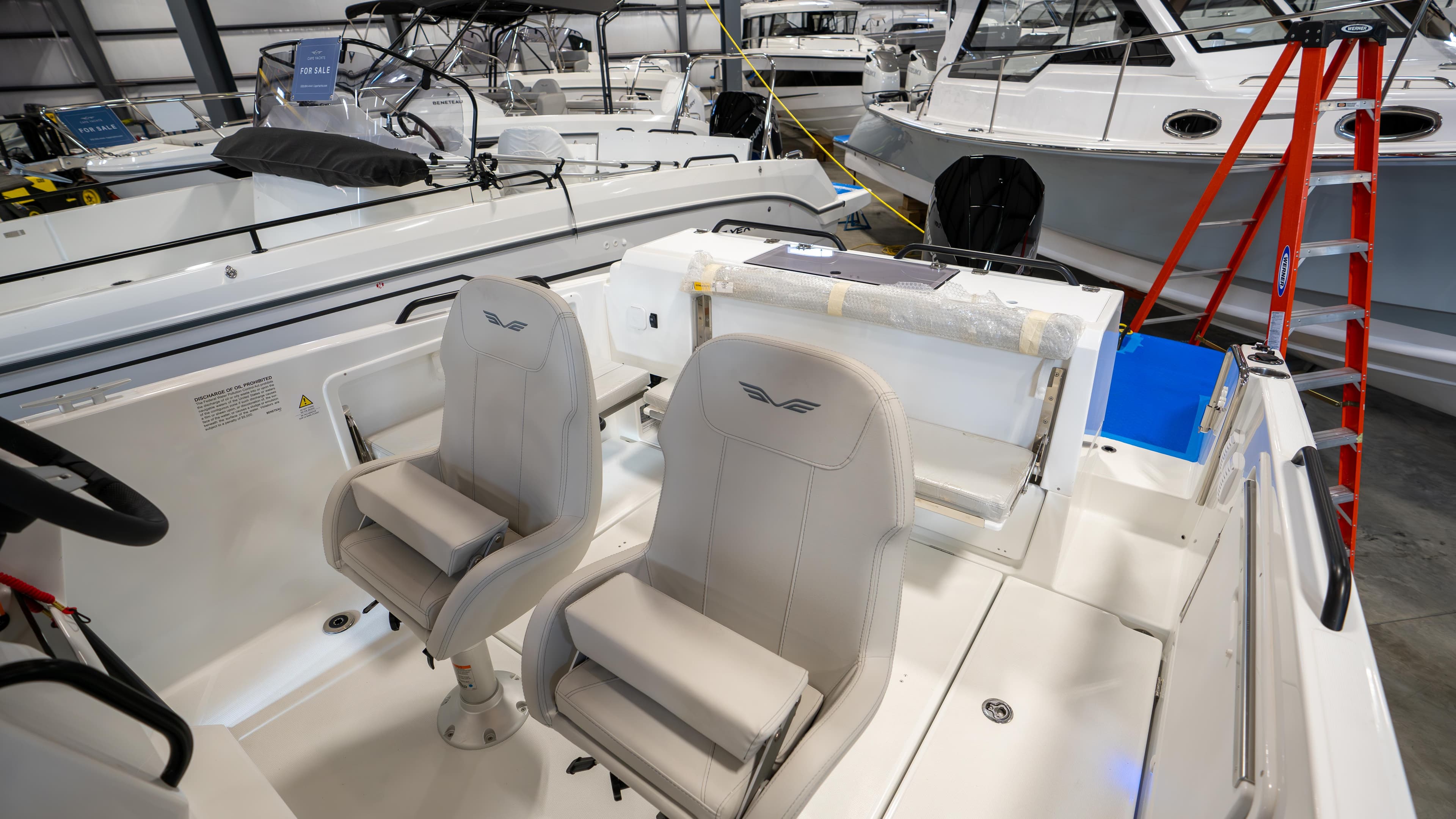 2023 Beneteau Flyer 8 SPACEdeck interior with dual seats in a showroom.