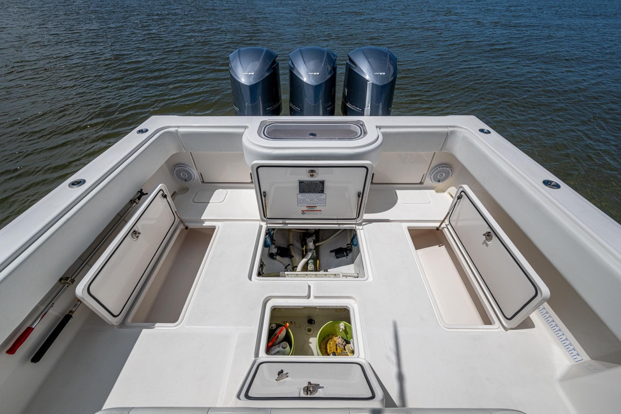 2015 Invincible 42 Open Fisherman boat deck with storage compartments and triple engines.