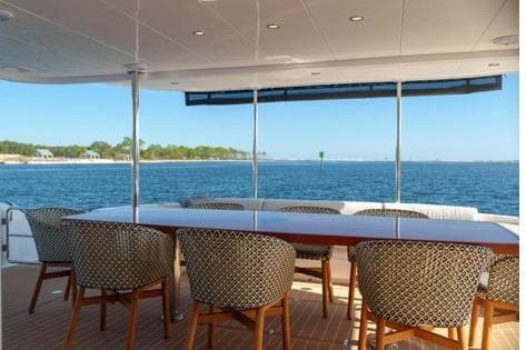 Luxury yacht Horizon PC65 2022, featuring elegant outdoor dining area with ocean view.