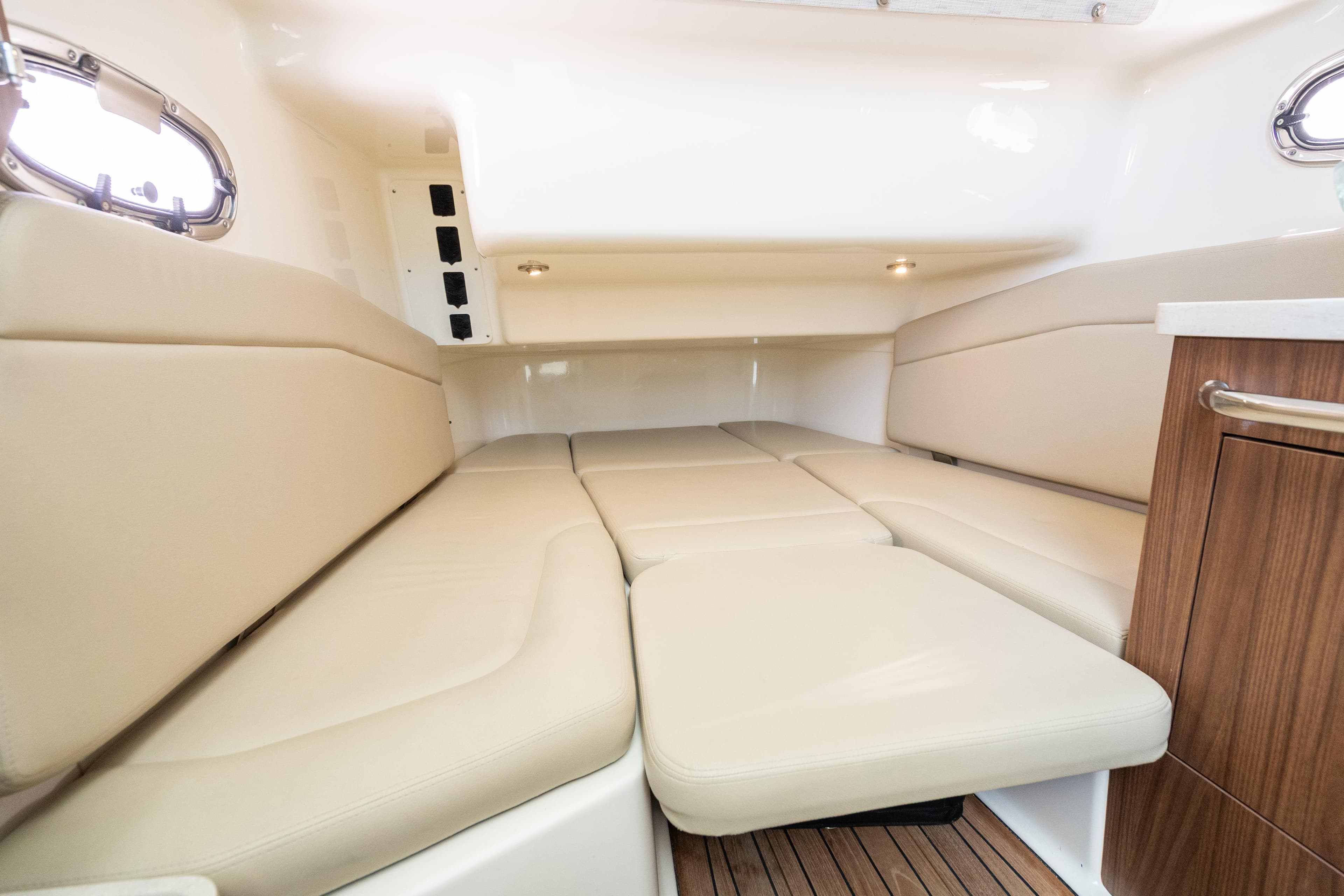 2020 Boston Whaler 380 Outrage cabin interior with beige seating and wood accents.