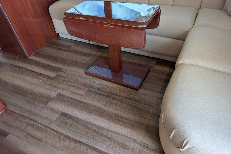 Interior of 2005 Egg Harbor 43 SportYacht with wooden table and beige seating.