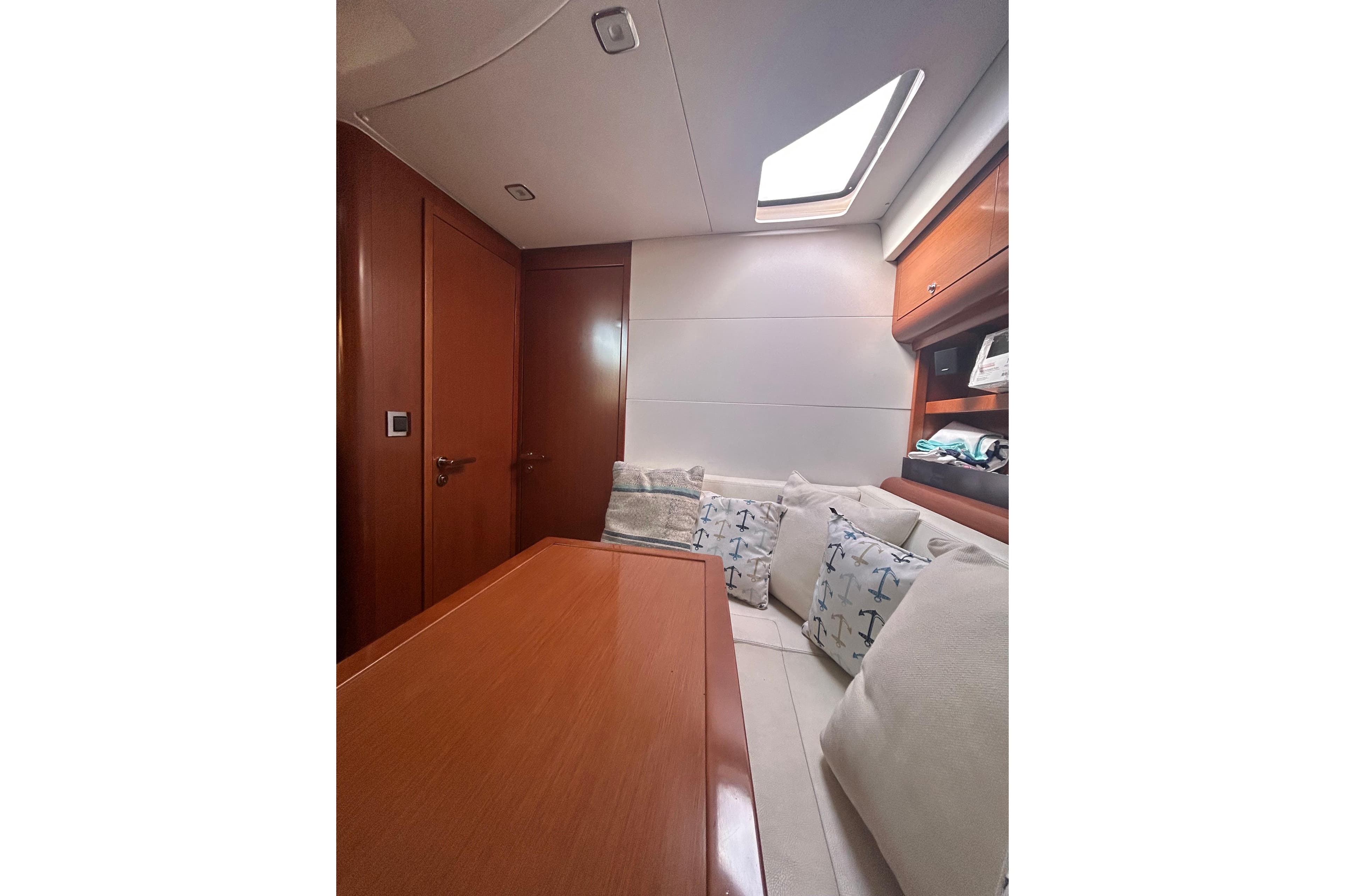 Interior of 2012 Beneteau Gran Turismo 44 yacht with cozy seating and wooden finishes.