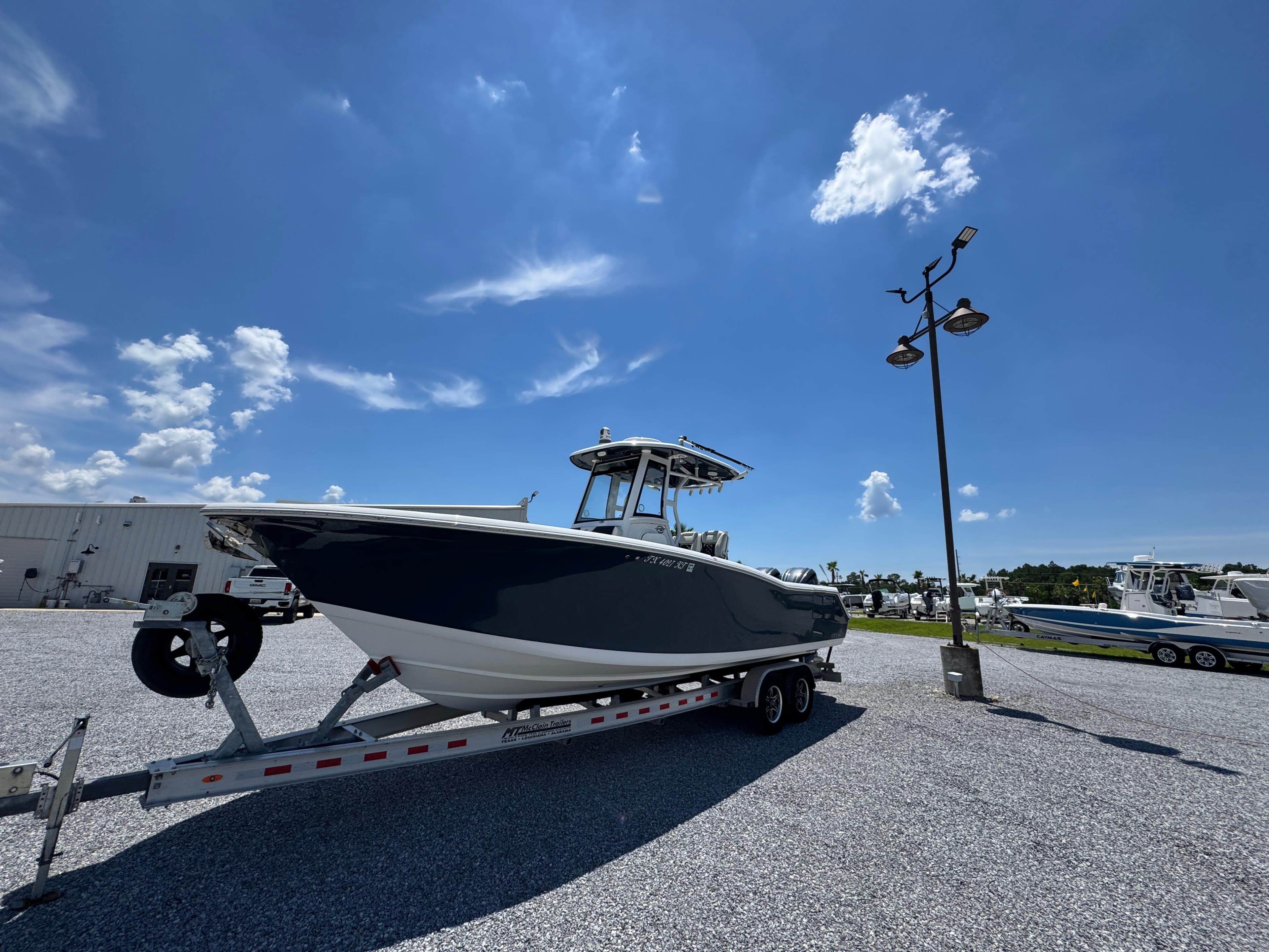 2023 Tidewater 282 CC Adventure Bluewater boat on trailer under clear blue sky.
