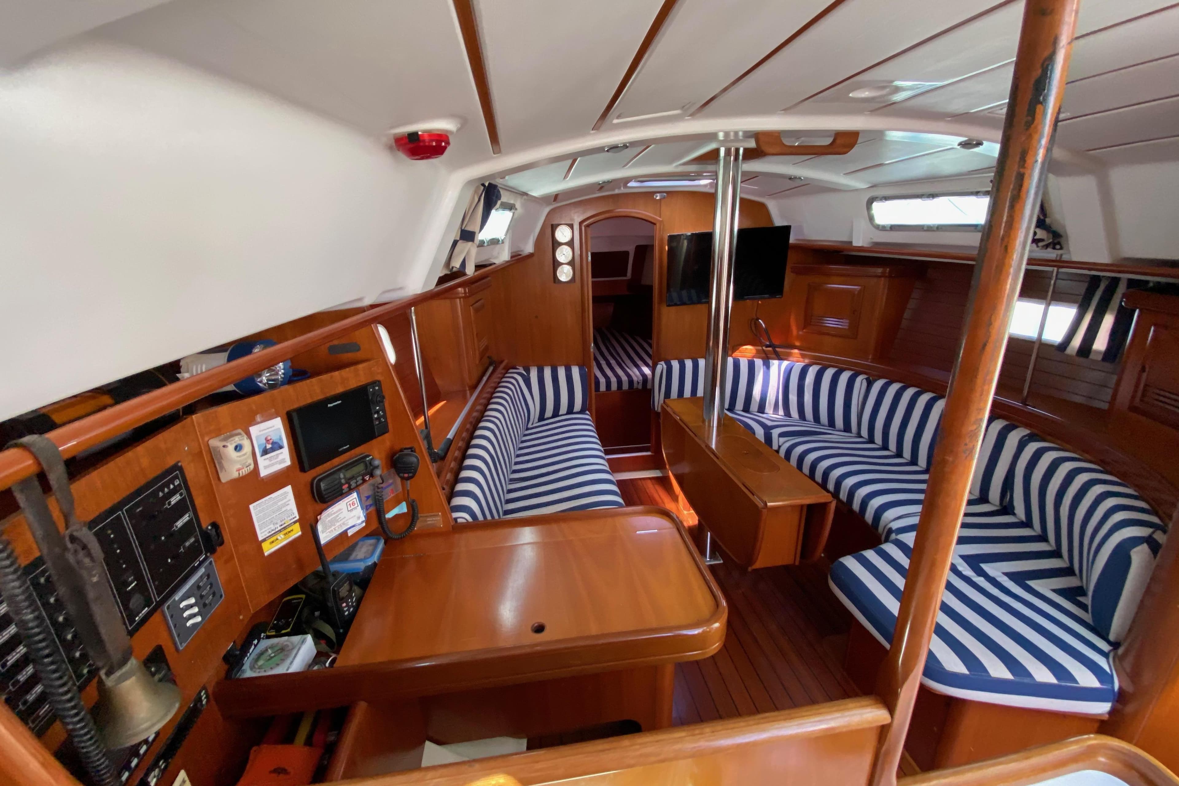 Interior of 2001 Beneteau Oceanis 361 sailboat with striped seating and wooden finishes.