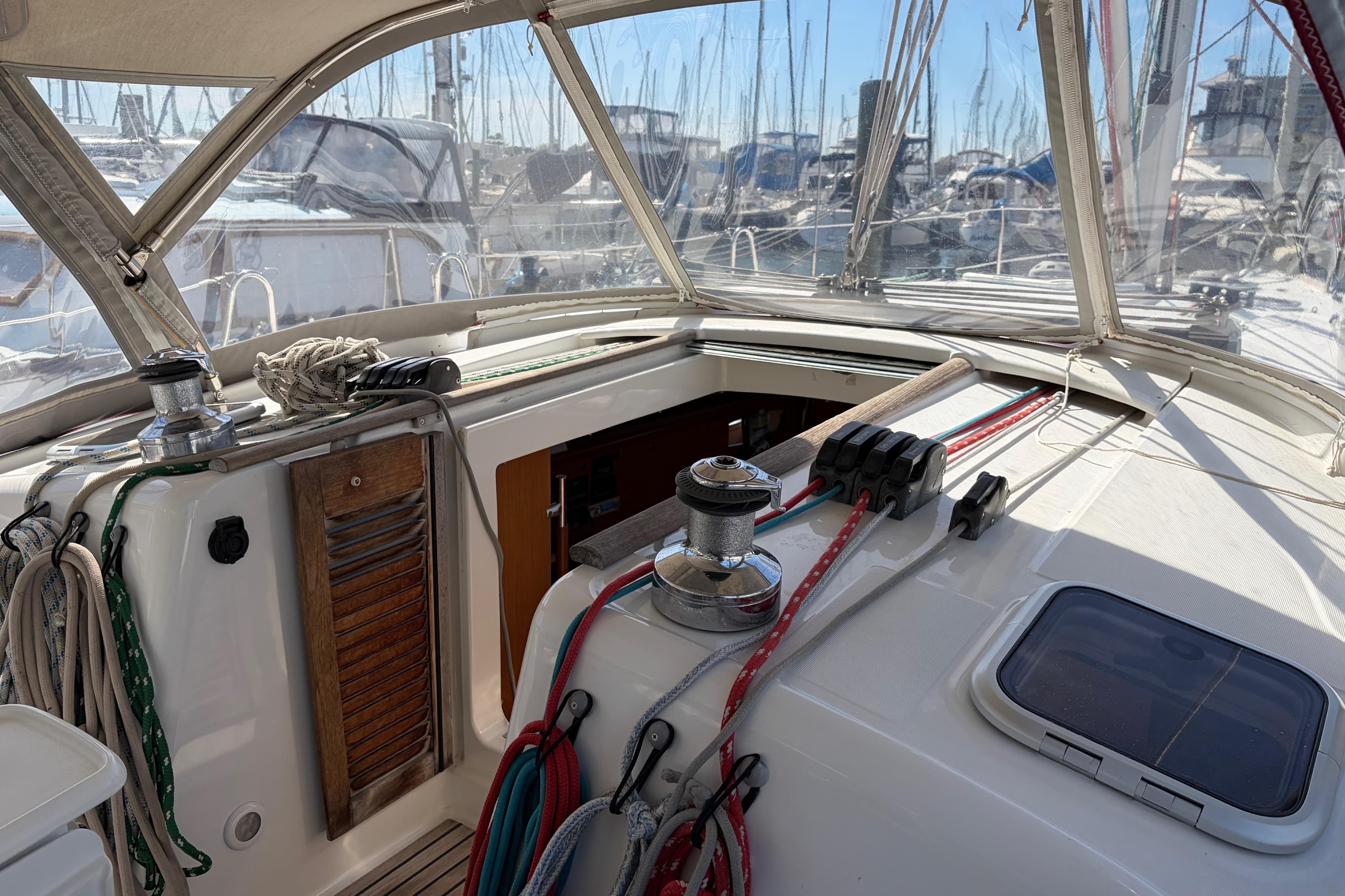 Cockpit of a 2008 Beneteau 43 sailboat with ropes and winches in a marina.