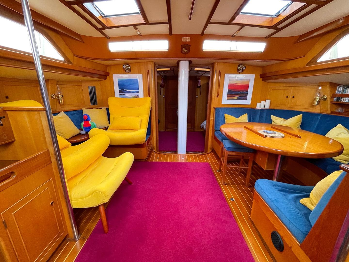 Luxurious 1985 Camper & Nicholsons 58 yacht interior with vibrant seating and elegant wood finishes.
