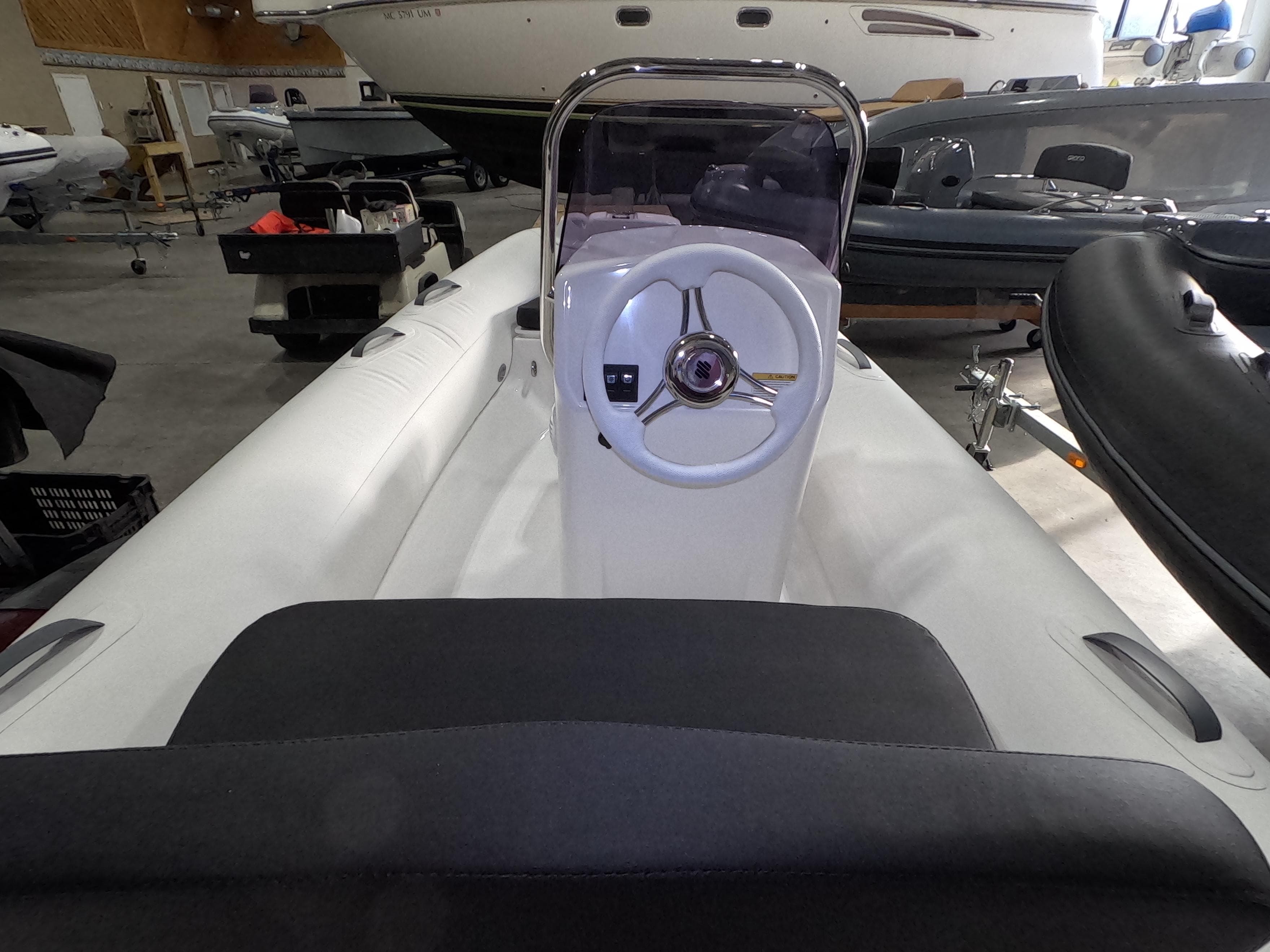 2024 Grand Inflatables S370NL boat interior with steering wheel and seating.