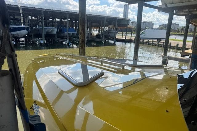 Yellow 2008 Baja 30 Outlaw boat docked in a marina under a sunny sky.