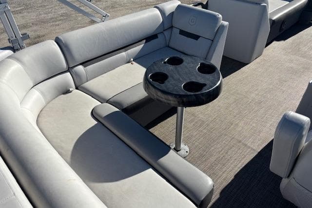 2022 Sweetwater 2286 pontoon boat interior with gray seating and a round table.