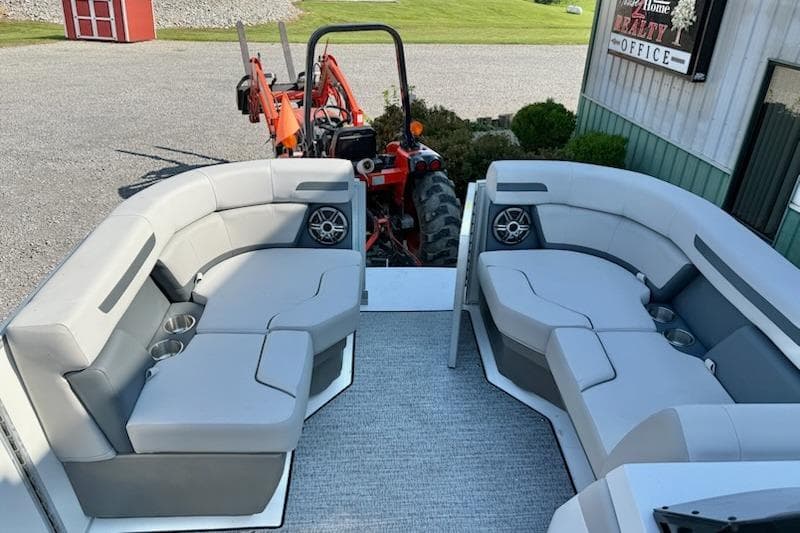 Luxurious seating on 2026 Hurricane FD1960RE3-OB boat, with a tractor in the background.