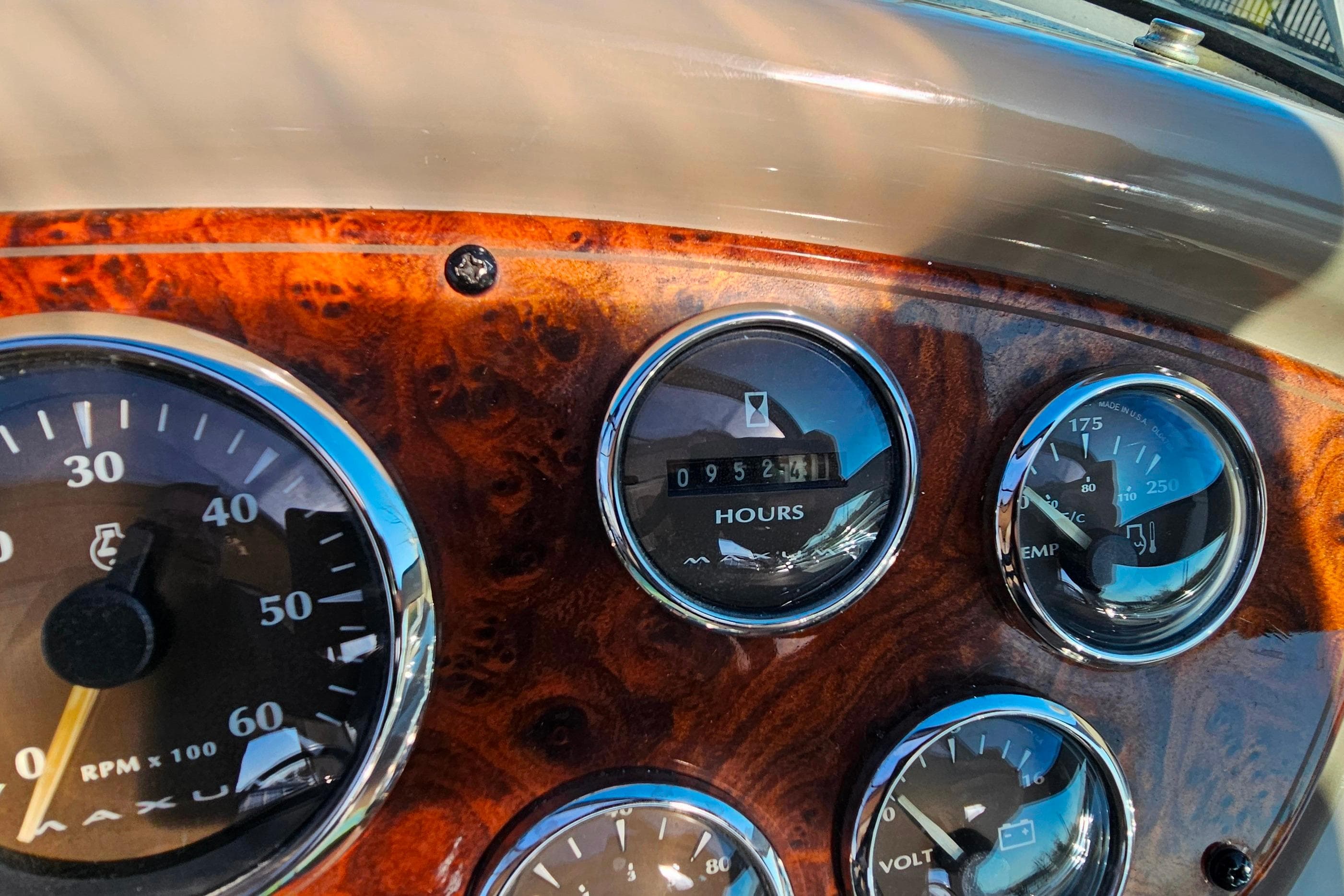 Dashboard of a 2001 Maxum 3500 SCR boat with gauges and wood finish.