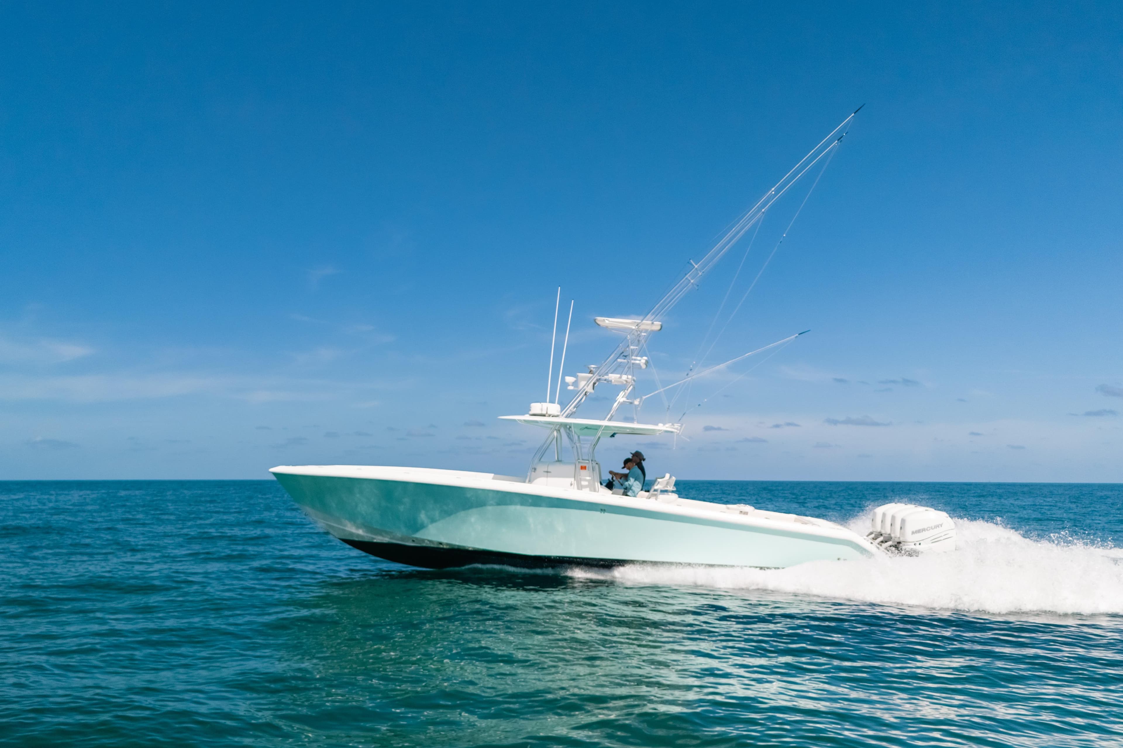 2006 Venture 39 Open boat cruising on open sea under clear blue sky.