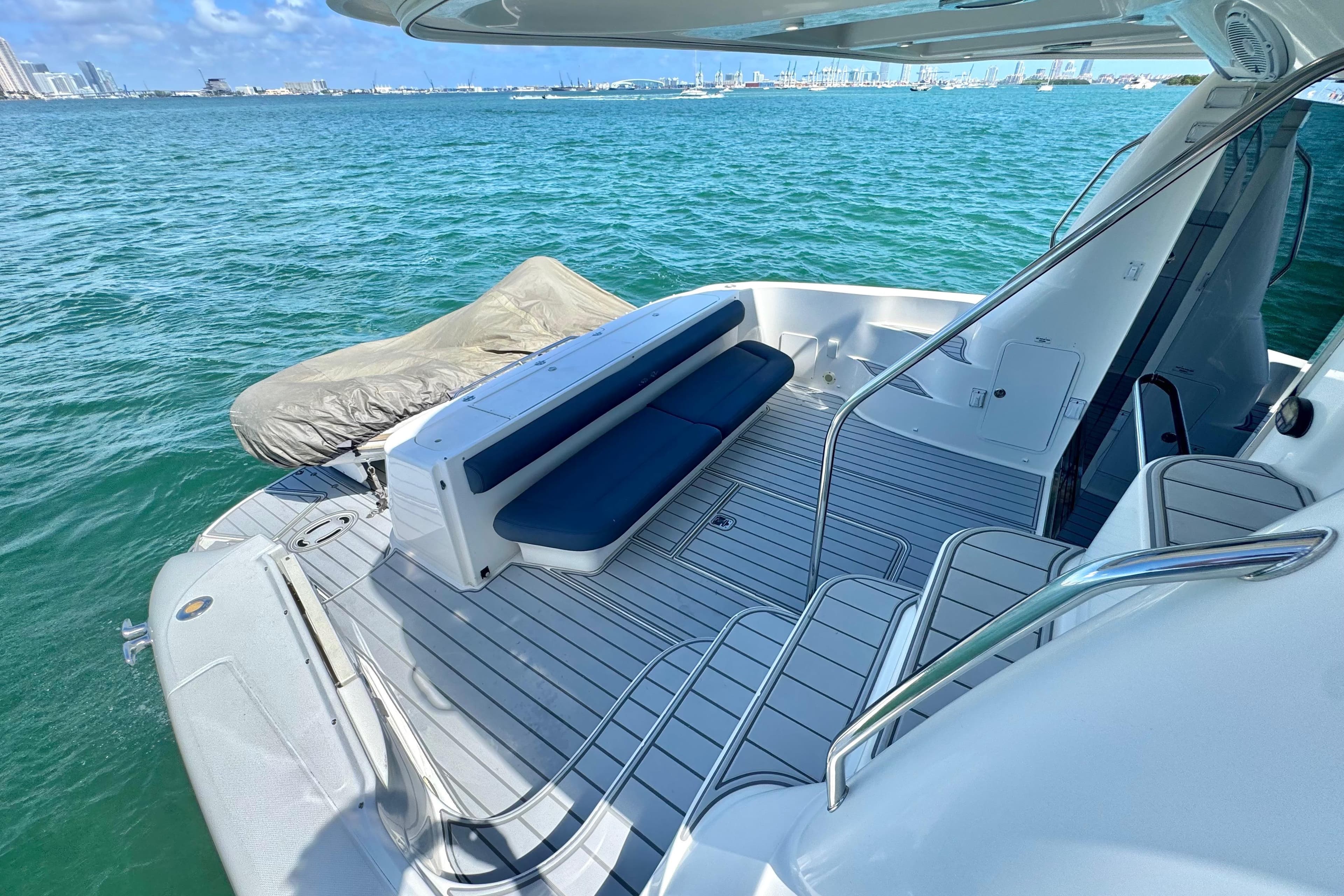 Luxurious 2005 Sea Ray 550 Sedan Bridge yacht deck with seating, overlooking serene ocean waters.