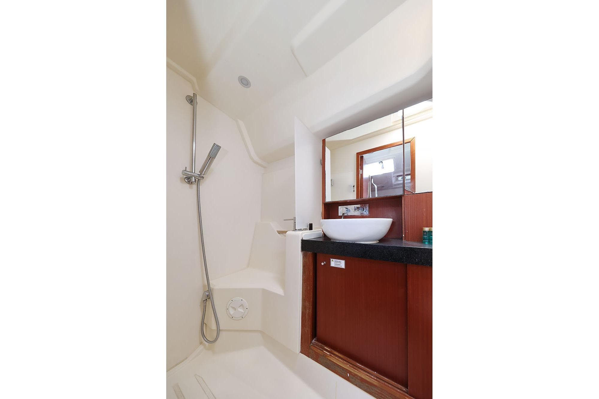 Modern bathroom interior of 2017 Hanse 455 yacht with shower and sink.