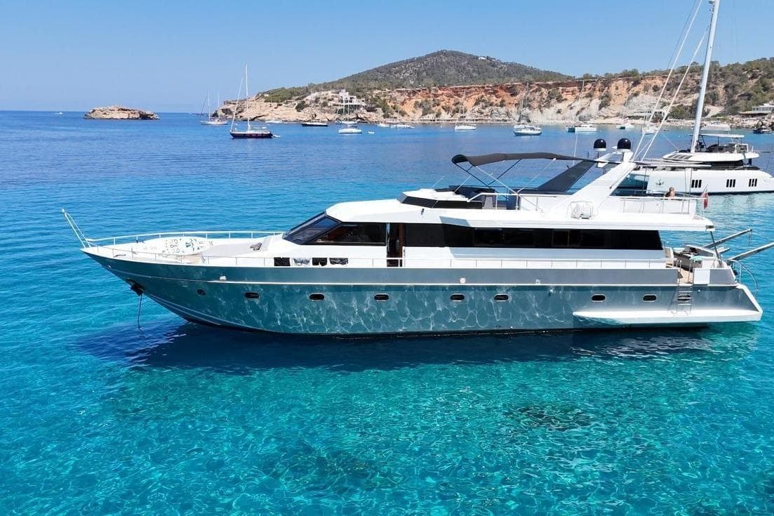 1987 Canados 88 yacht on clear blue water with scenic coastal backdrop.