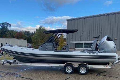 2026 Brig Eagle 8 boat on trailer, parked outdoors near industrial building.
