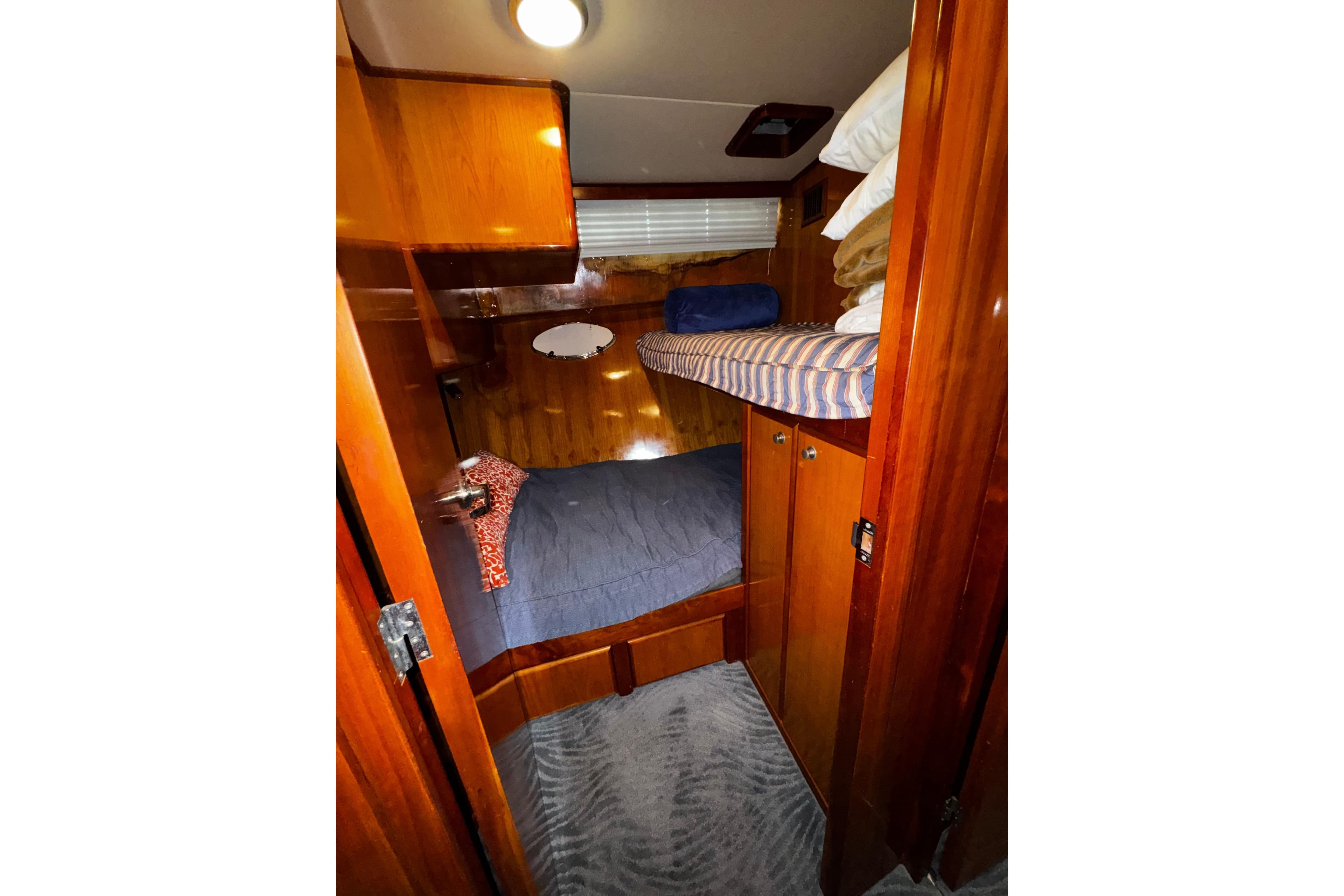 Cozy cabin interior of 1998 Mikelson 43 Sportfisher with wooden finish and bunk beds.