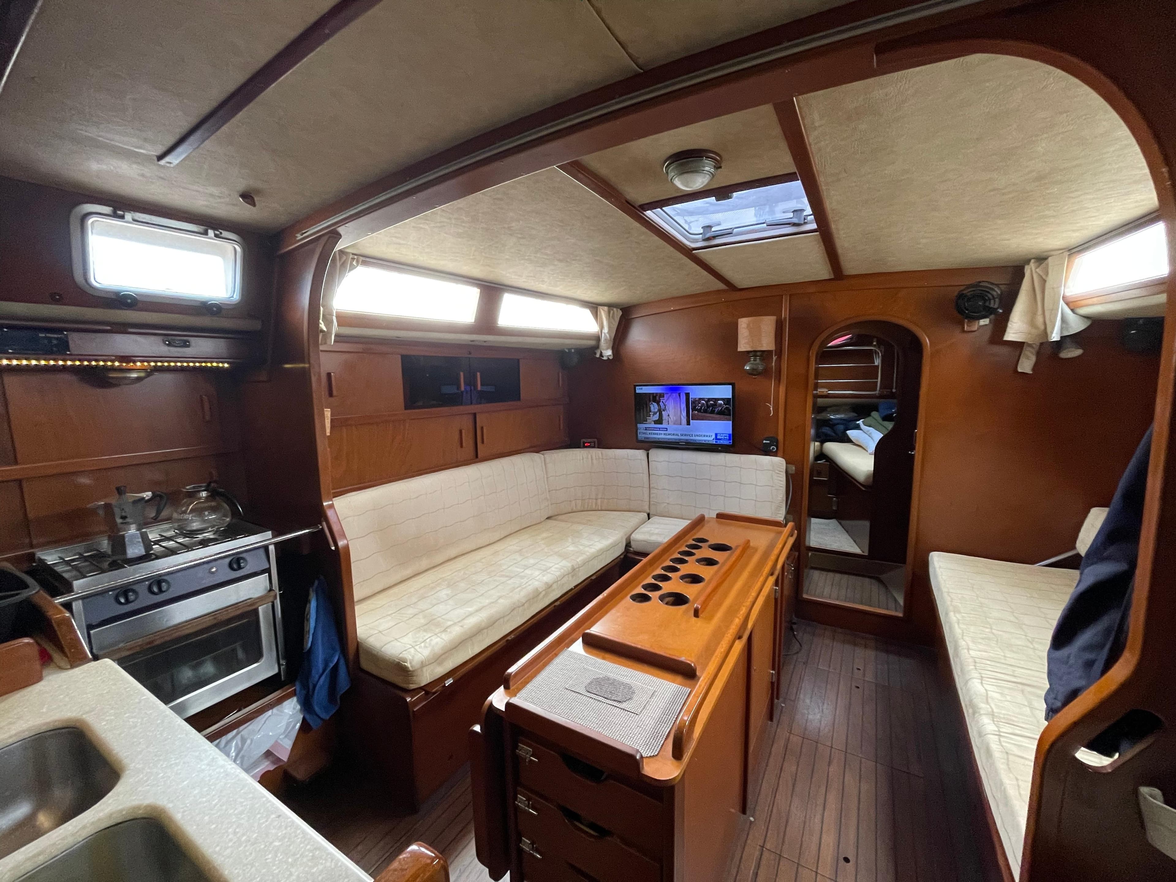 Interior of 1985 Amel Maramu sailboat with cozy seating and kitchen area.