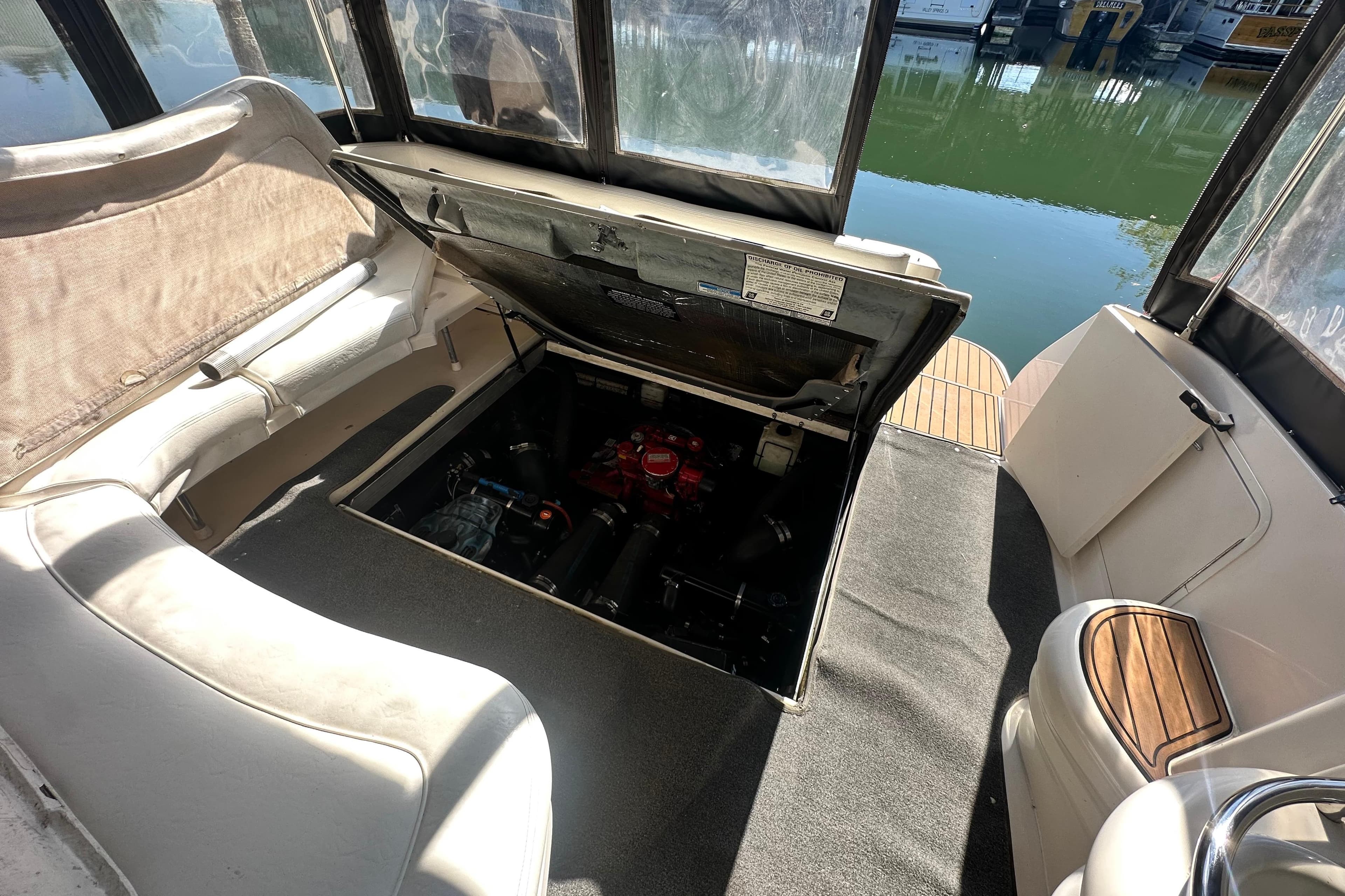 2000 Sea Ray 310 Sundancer boat interior with open engine compartment, docked by the water.