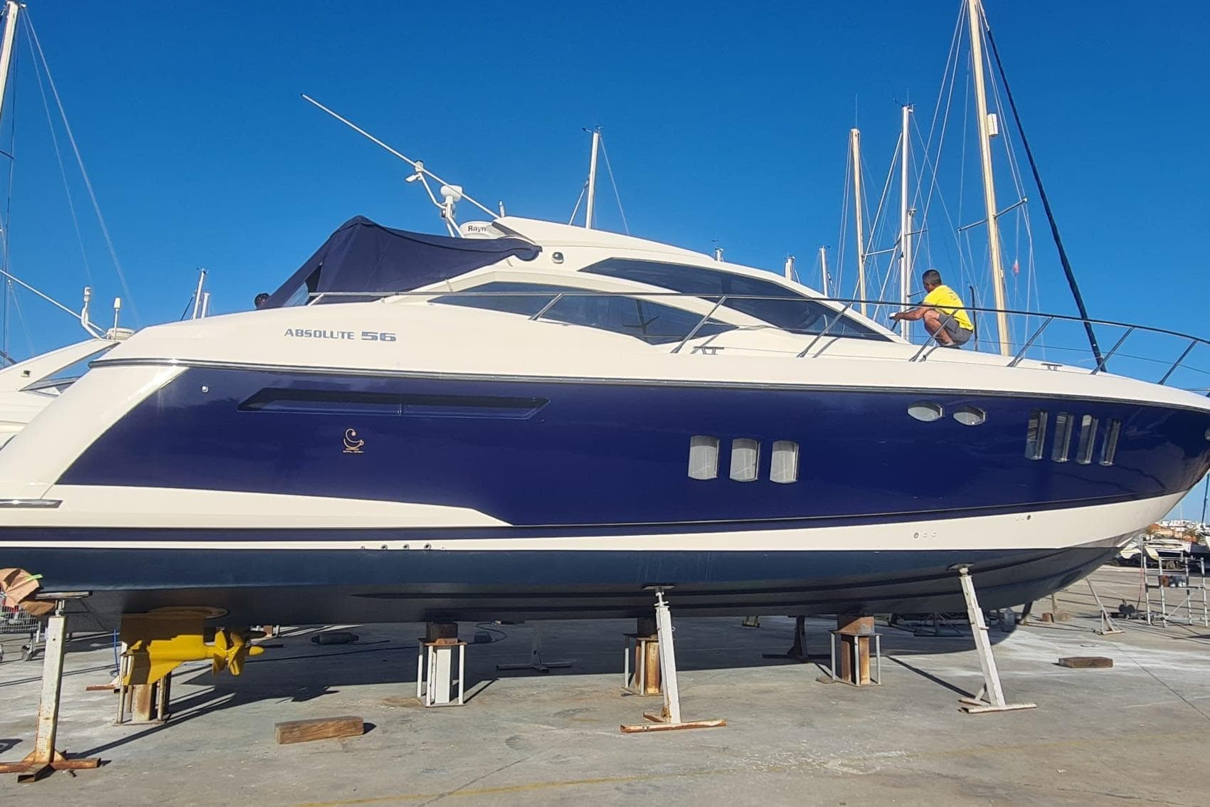 2007 Absolute 56 yacht on dry dock with a person working on deck.
