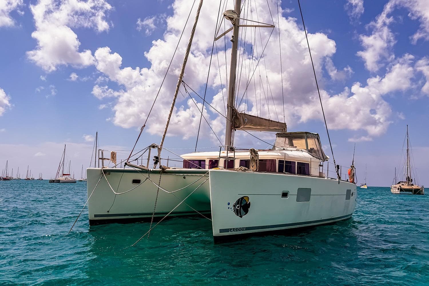 2010 Lagoon 400 catamaran sailing on clear blue waters under a partly cloudy sky.