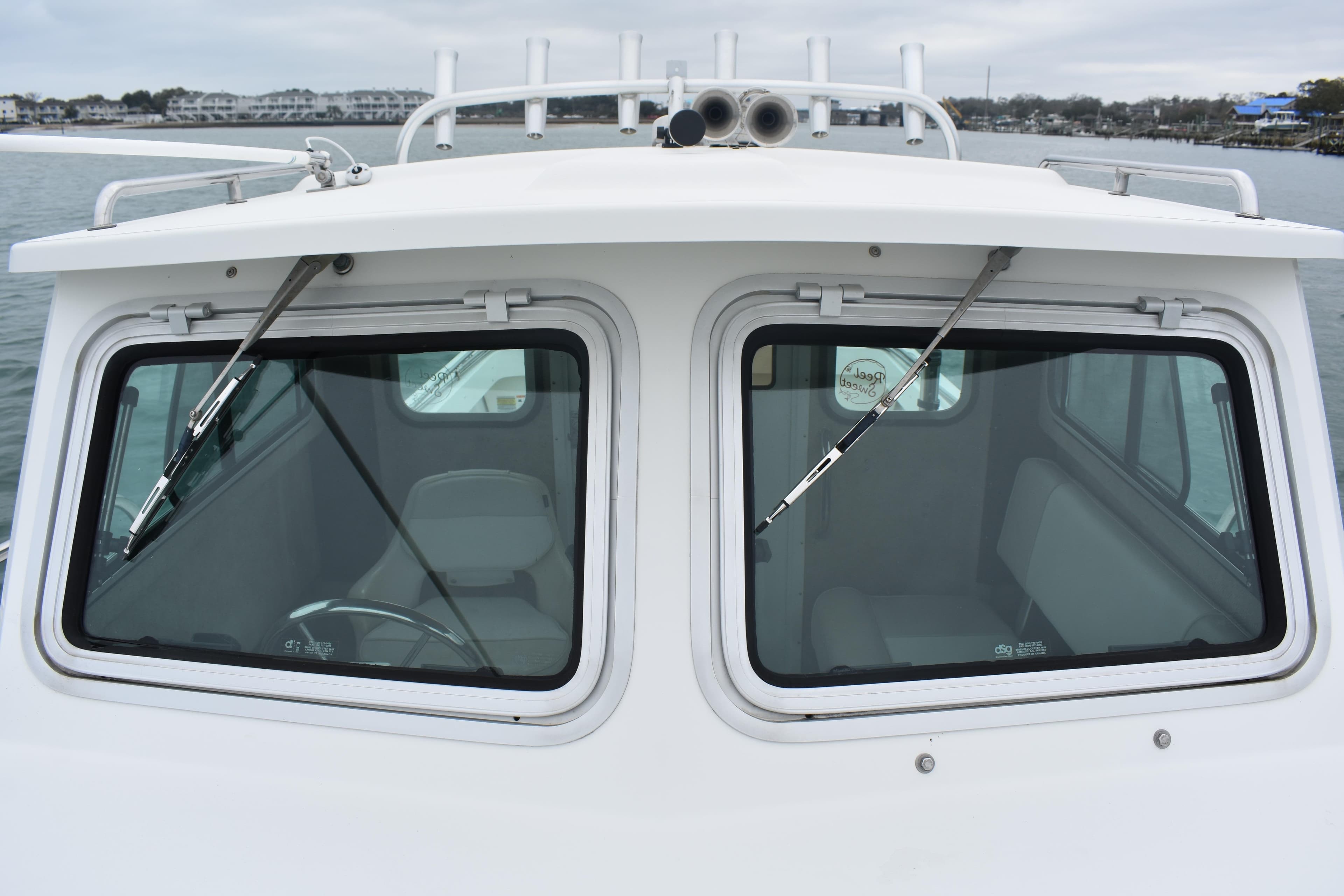 2015 Parker 2320 SL Sport Cabin boat with dual windshield wipers on calm water.