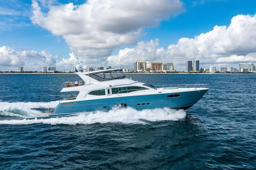 Luxury yacht Lanzarote Ventuno 73 cruising on ocean, city skyline in background, 2013 model.