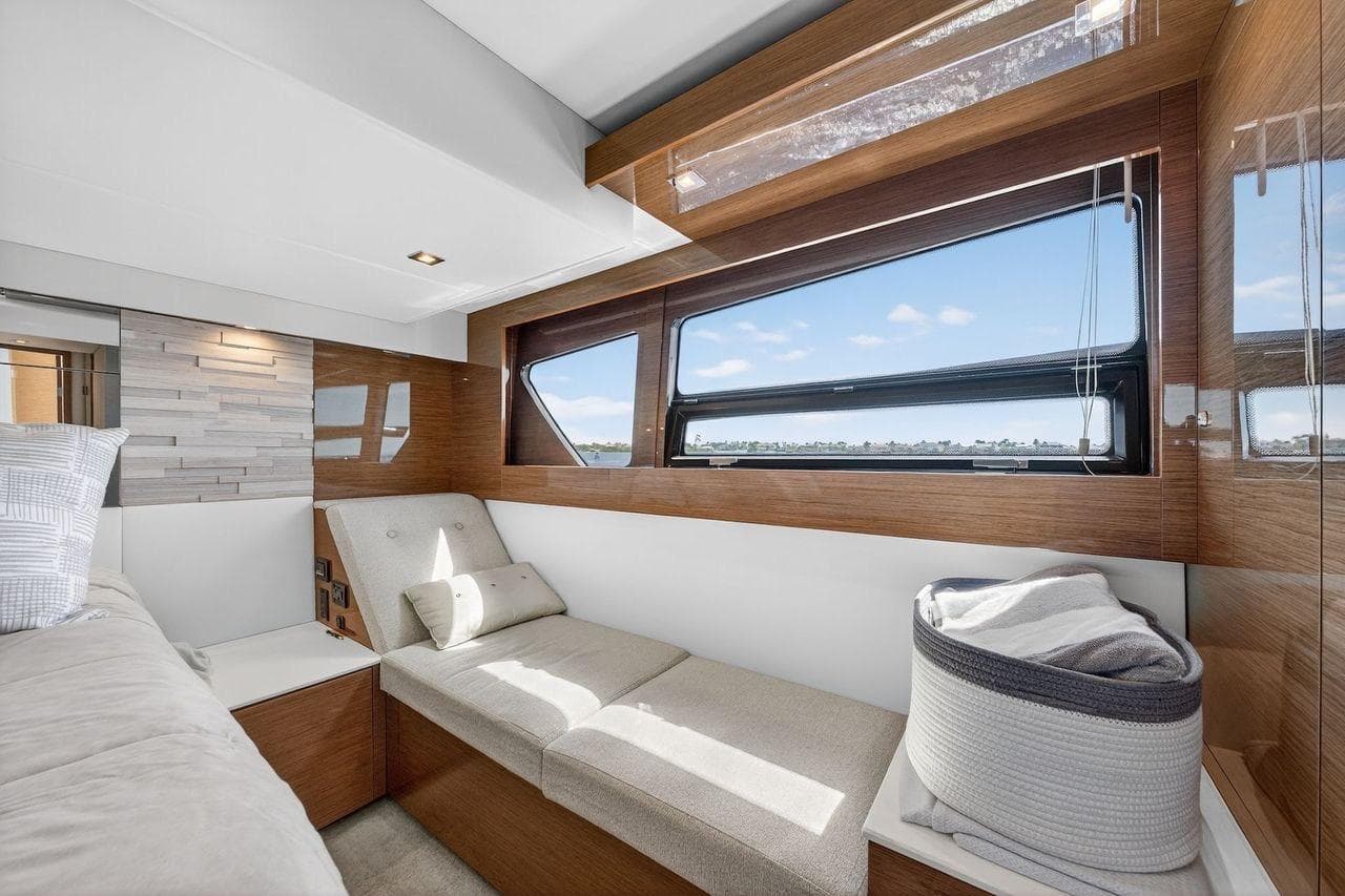 Luxurious interior of 2020 Cruisers Yachts 50 Cantius with modern seating and large window view.
