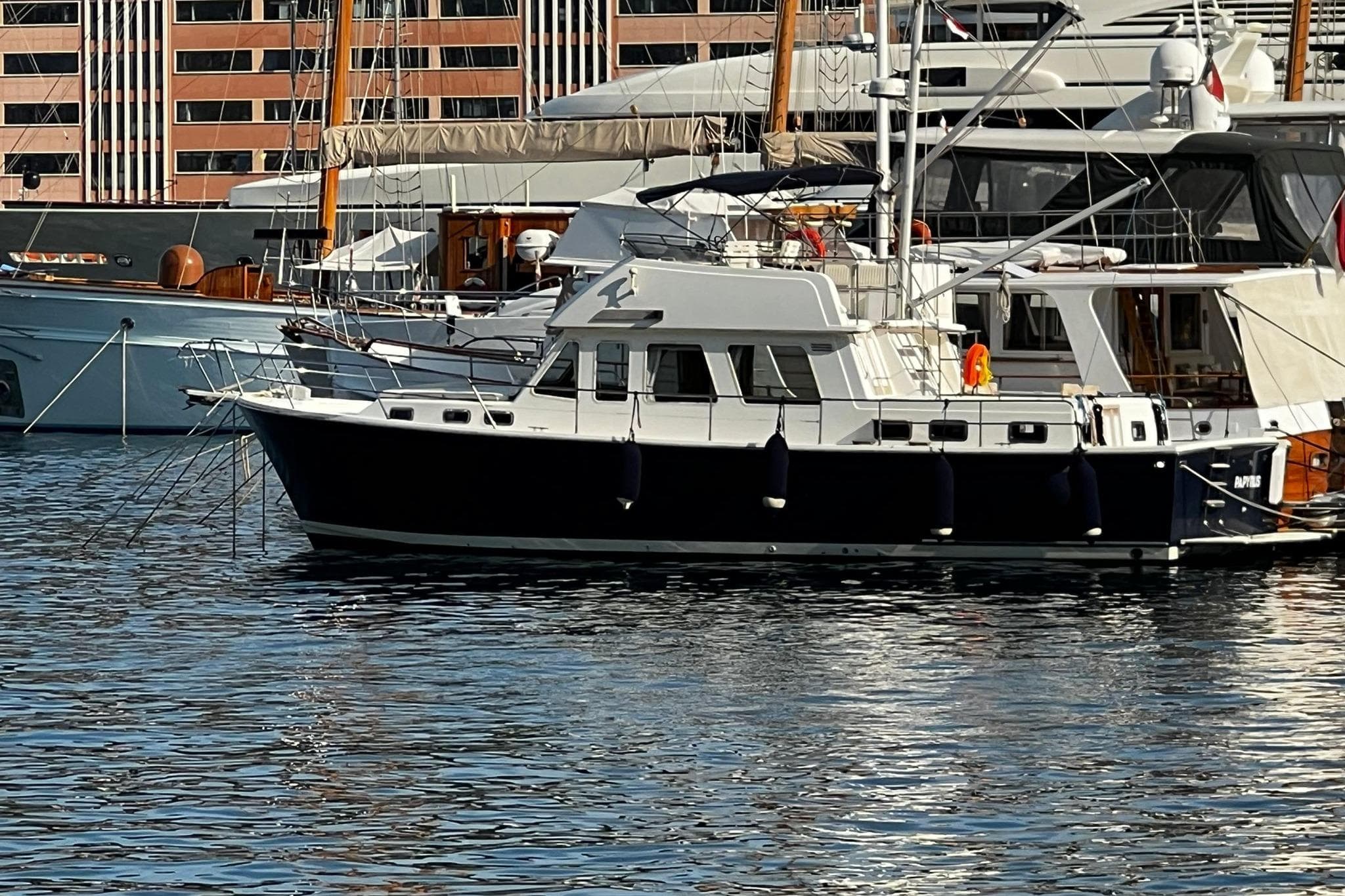 1997 Sabre SABRELINE 474 Trawler docked in a marina, surrounded by other boats.