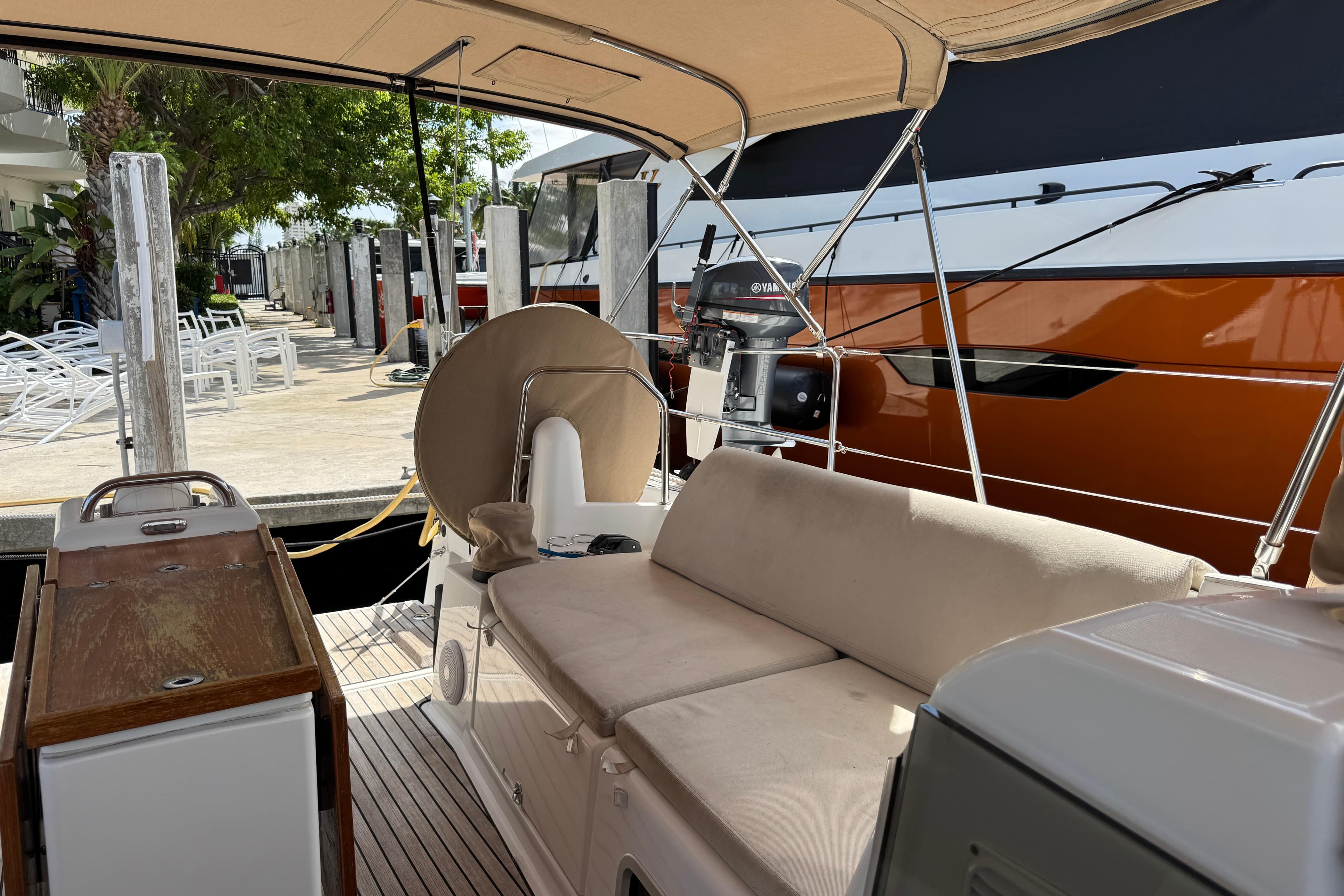 Jeanneau Sun Odyssey 440 yacht cockpit with seating, docked beside a large boat.