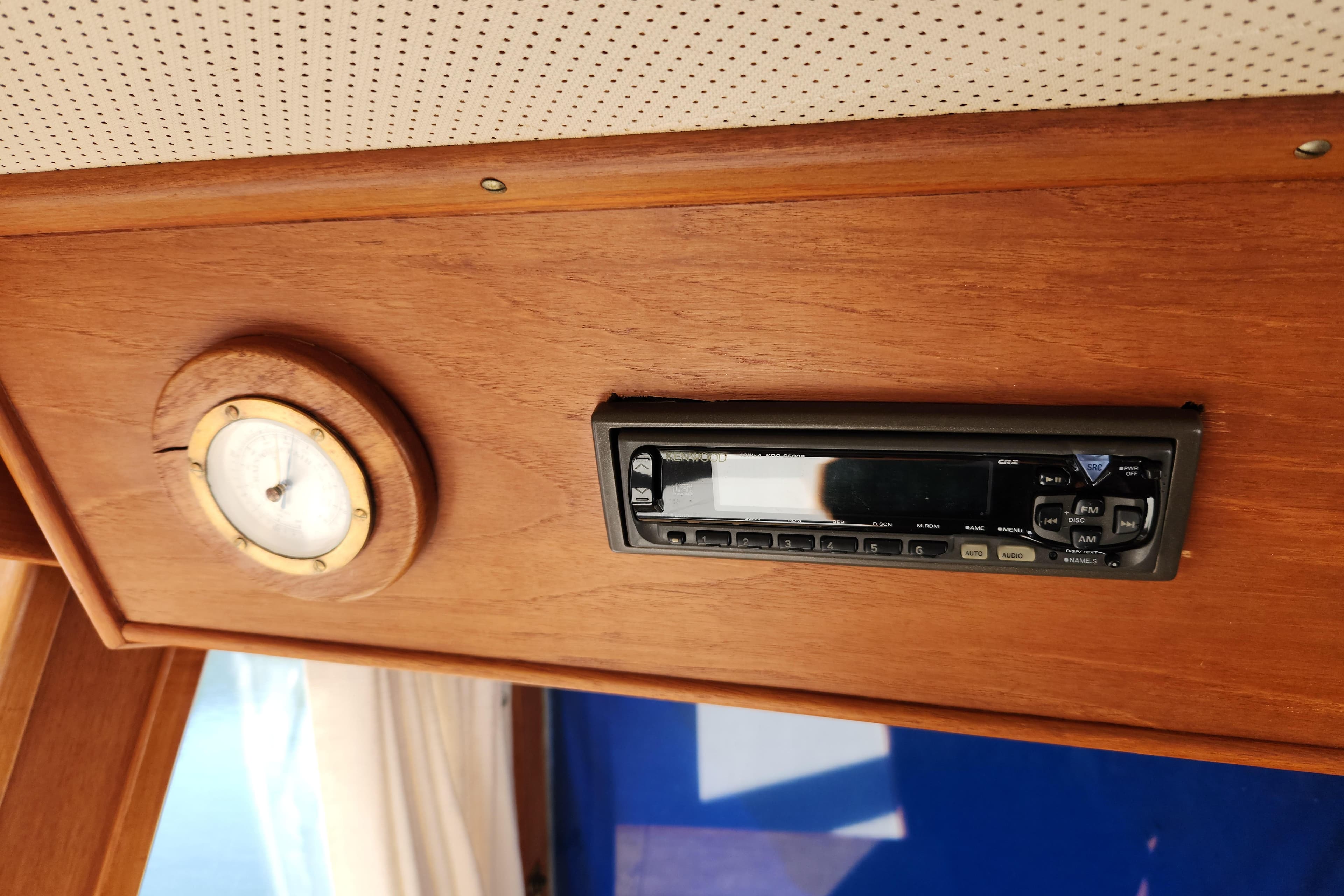 1983 Grand Banks 36 Classic interior with wooden paneling, featuring a stereo system and gauge.