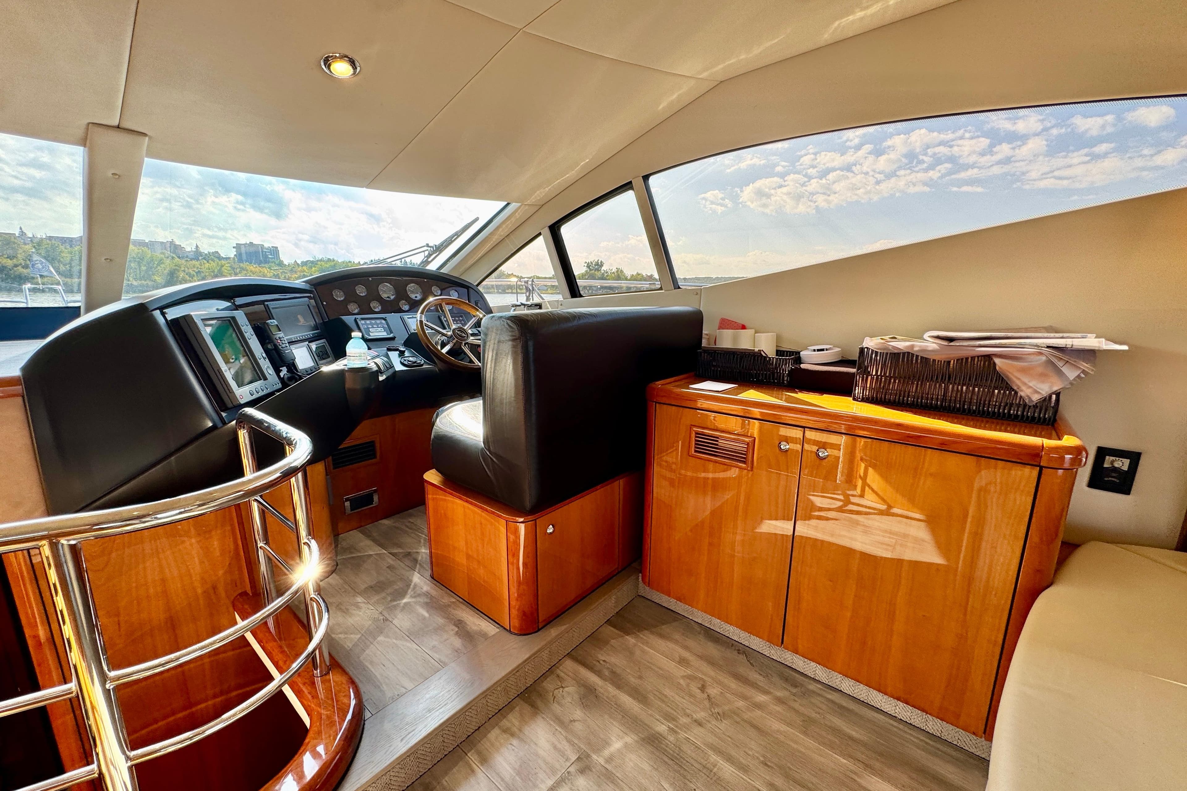 Luxurious 2005 Sunseeker Manhattan 50 yacht interior with sleek helm and wooden cabinetry.