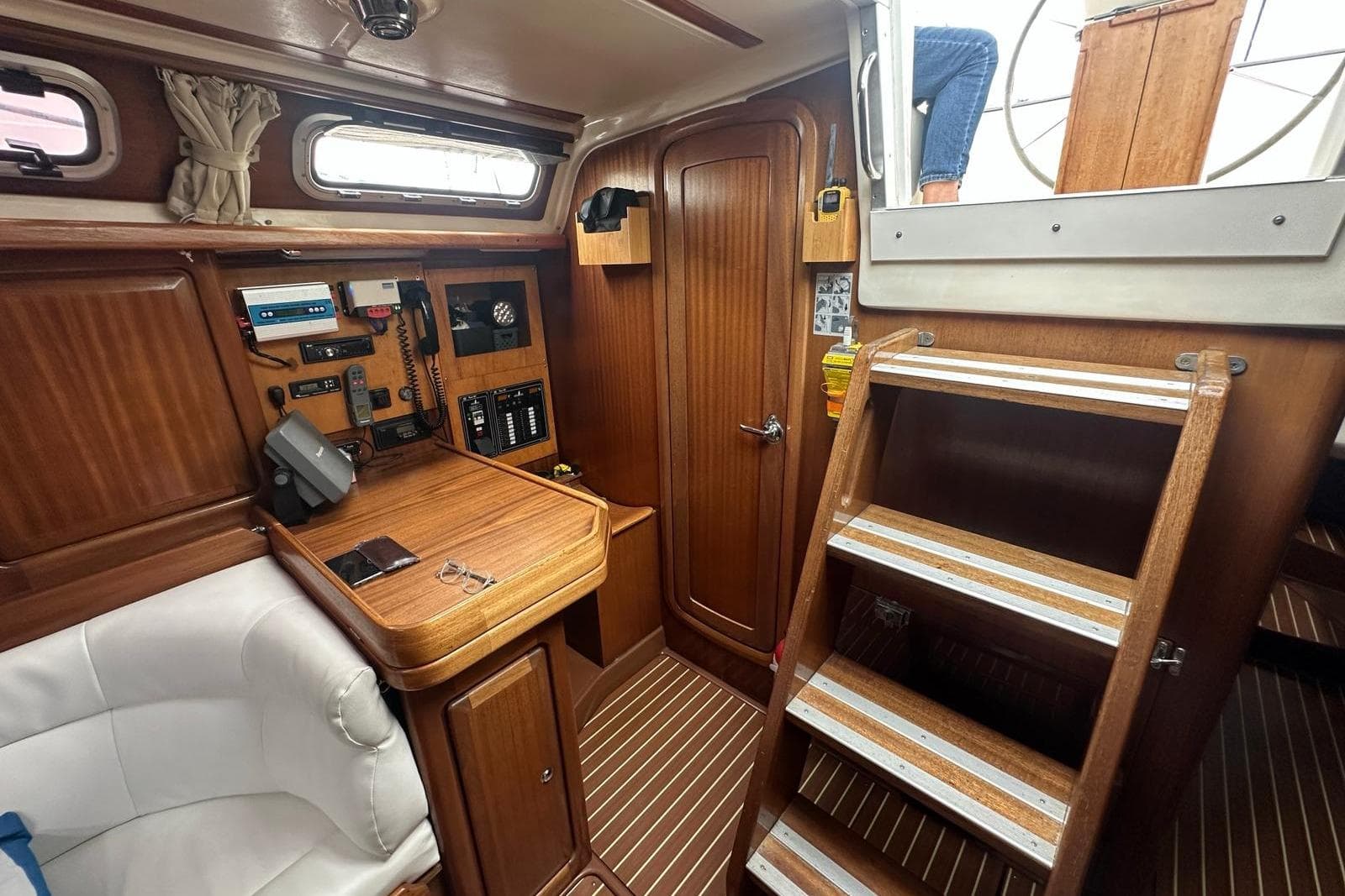 Interior of 1999 Bavaria Yachts 38 Ocean, featuring navigation station and wooden cabinetry.
