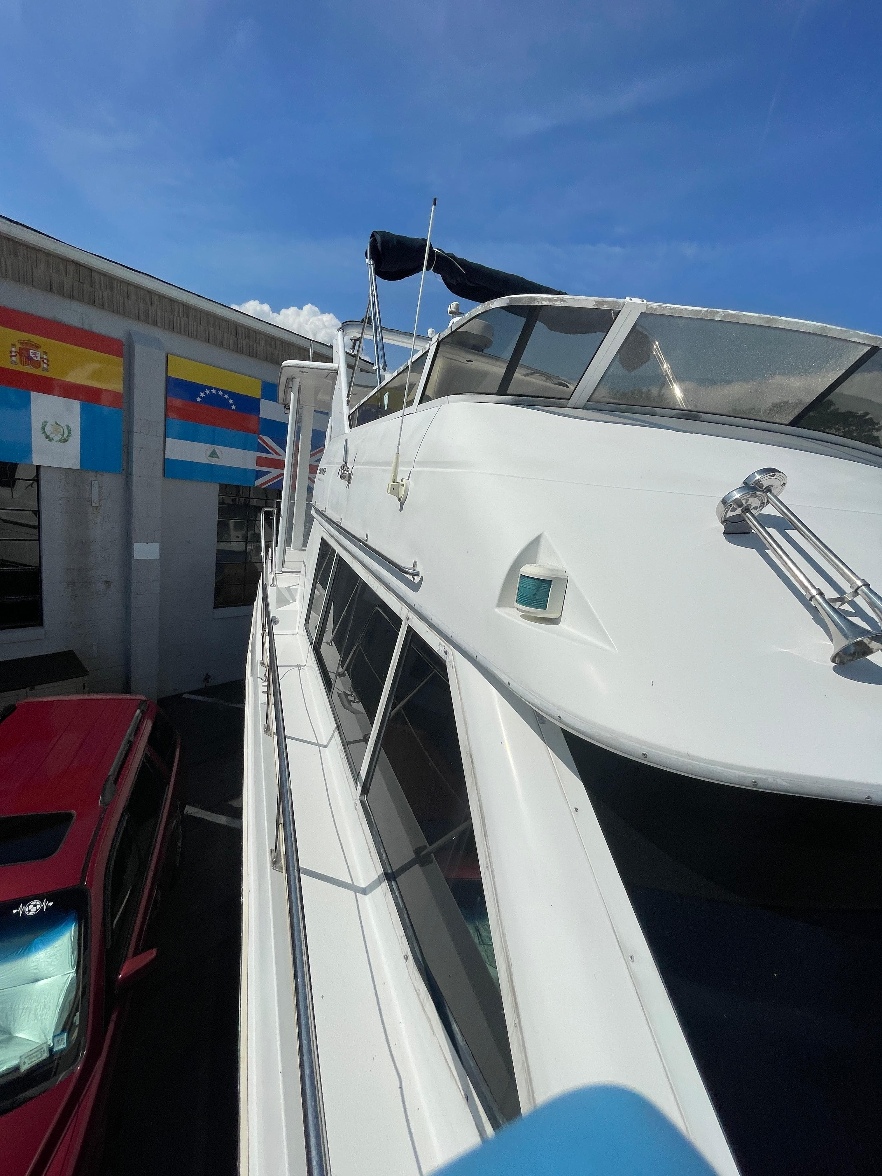 1997 Carver 405 yacht docked near flags and a red vehicle.
