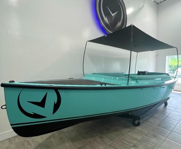 2023 Vision Marine Technologies Fantail 217 boat with canopy, displayed indoors.