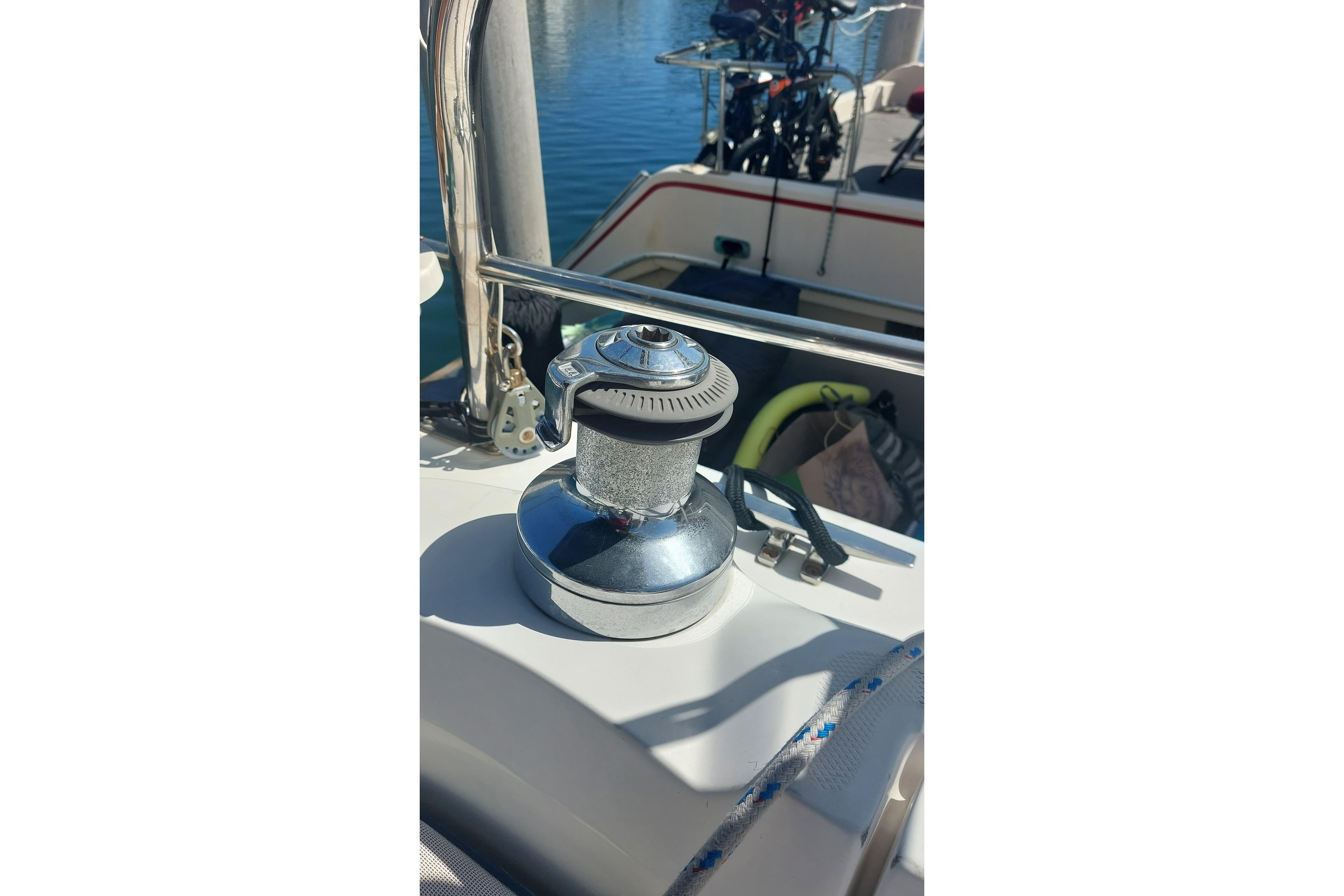 Winch on 2005 Hunter 38 sailboat deck, with marina background.