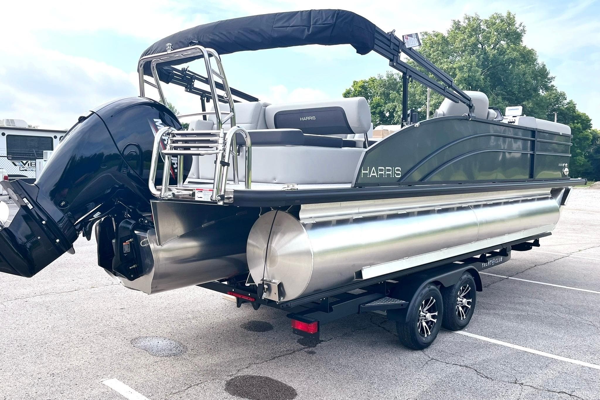 2025 Harris Cruiser 230 pontoon boat on trailer, featuring sleek design and powerful outboard motor.